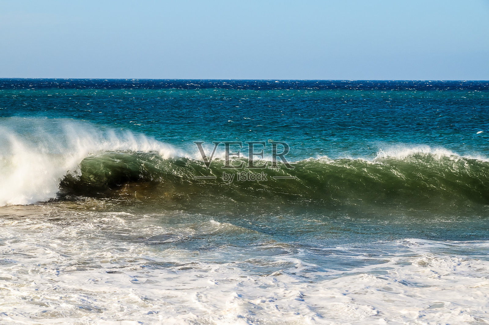 海洋平静而蔚蓝,远处有波浪拍打的声音。照片摄影图片