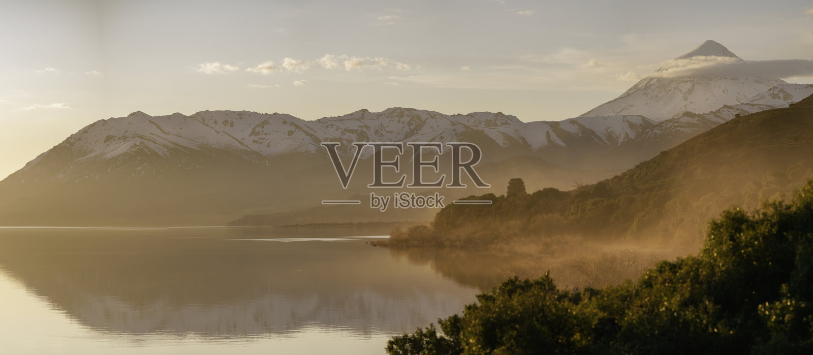 拉尼火山旁的胡埃丘拉夫肯湖全景,金色薄雾中的日出。阿根廷,巴塔哥尼亚。照片摄影图片