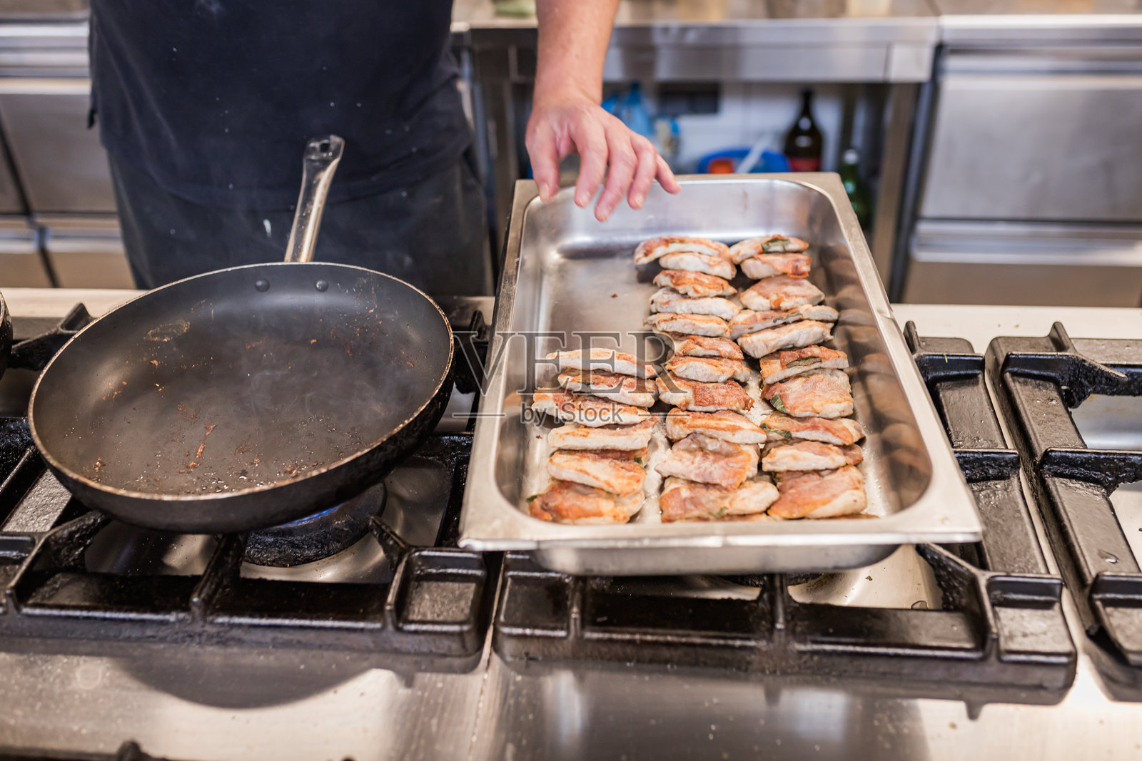 厨师在专业厨房中准备美味的肉类菜肴照片摄影图片
