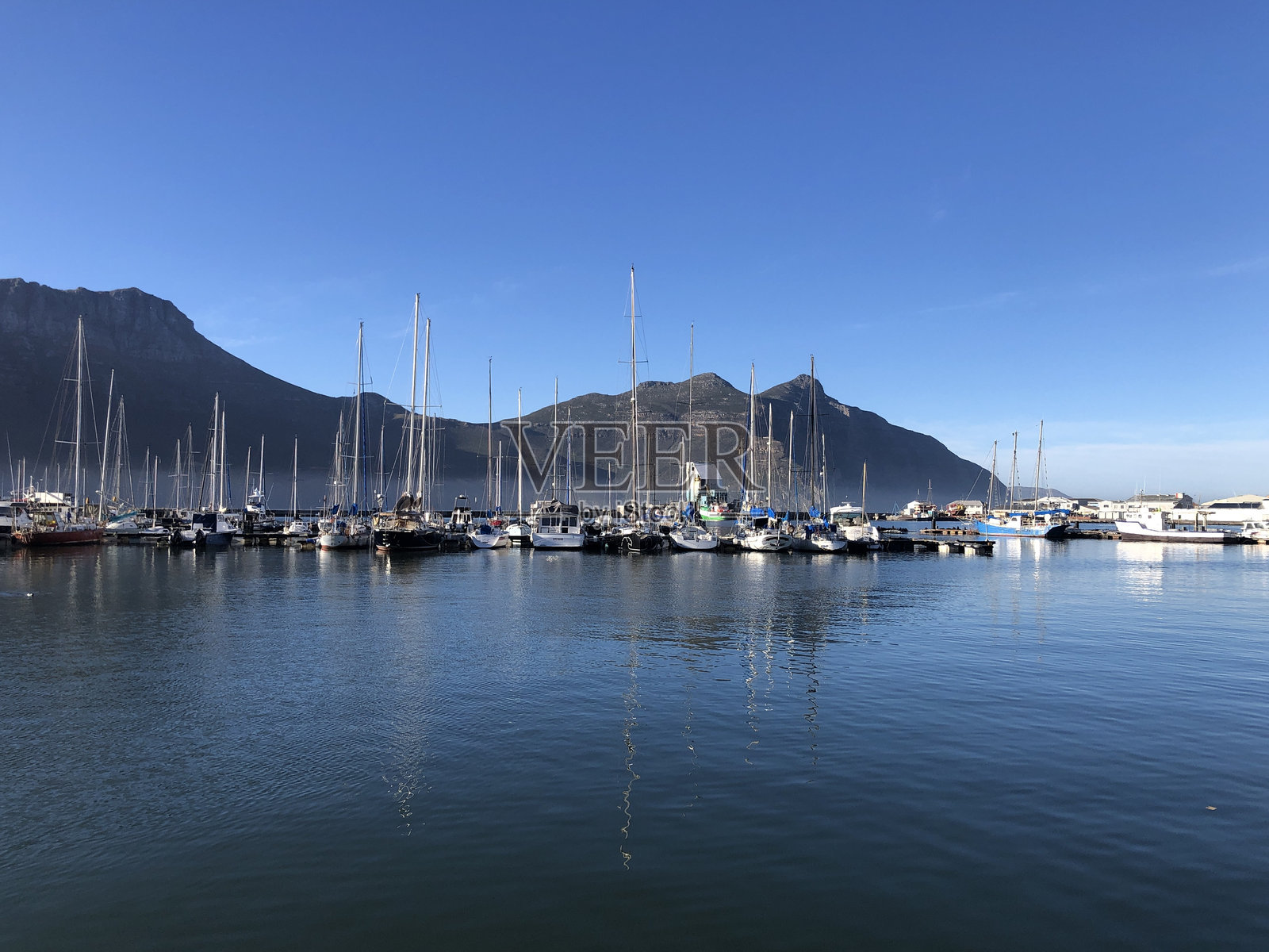 南非开普半岛的霍特湾港口,阳光照射下的水面倒影。照片摄影图片