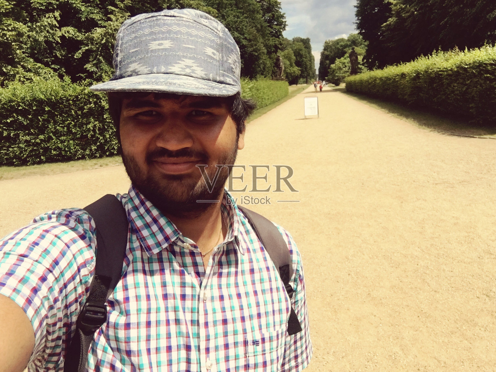 在正式花园的步道上,男人在树木间自拍照片摄影图片