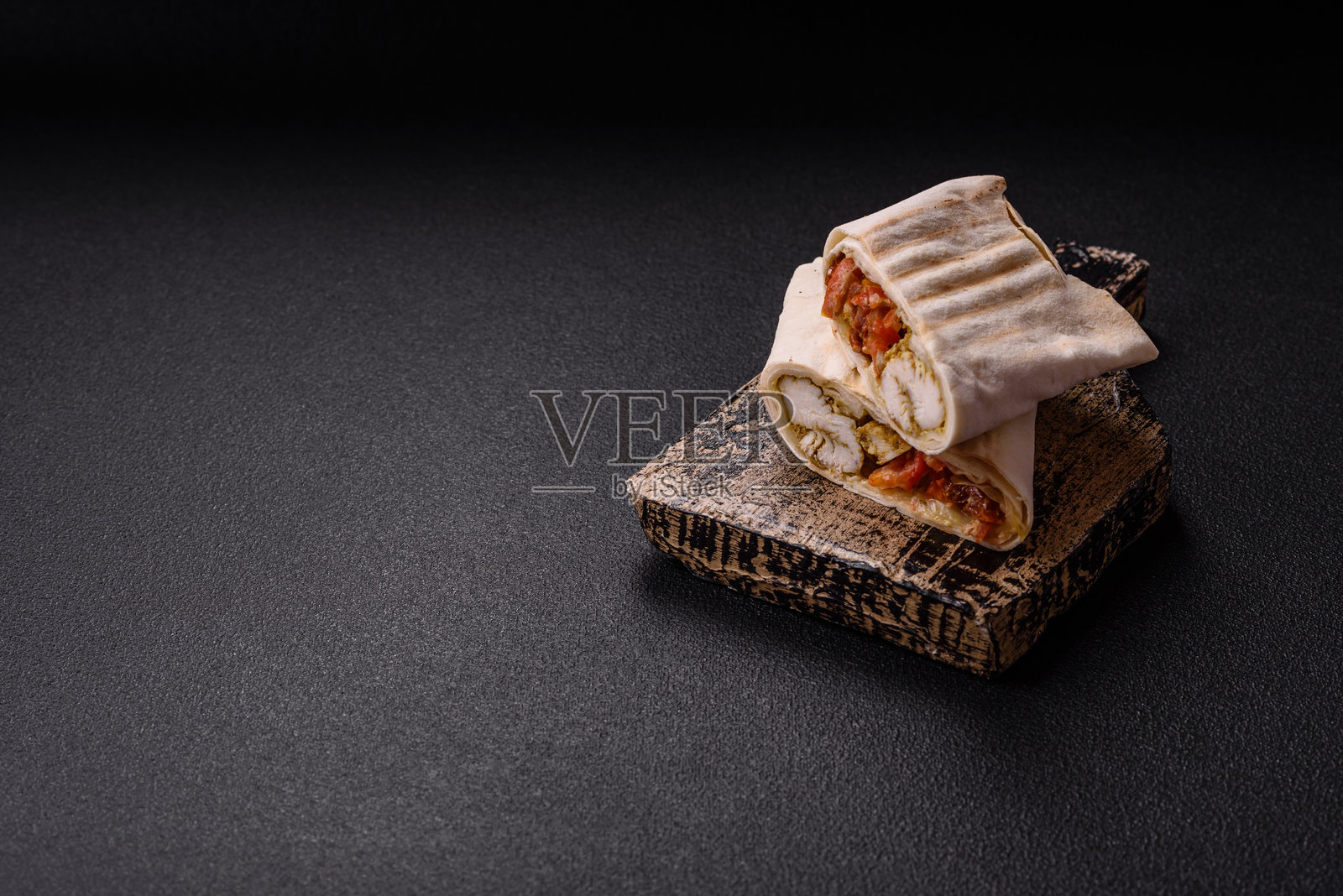 用皮塔饼卷肉、番茄、奶酪、酱汁、盐和香料照片摄影图片