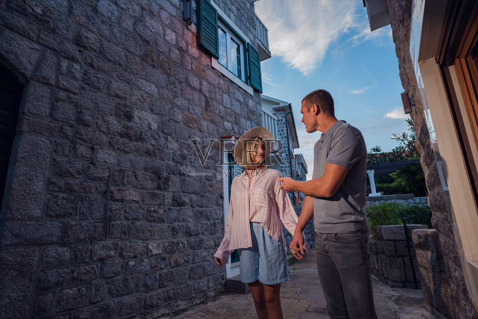 迷人的探索:情侣在安静的夜晚享受沿海村庄古朴的街道照片摄影图片