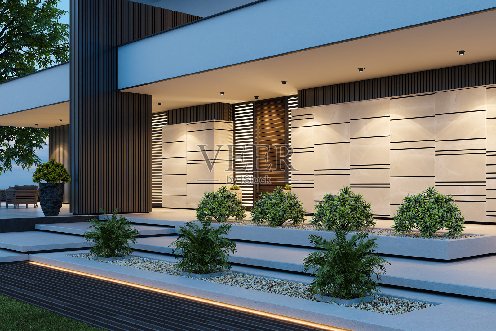 现代别墅,壮观的石材外立面和日落时分的前院照片摄影图片