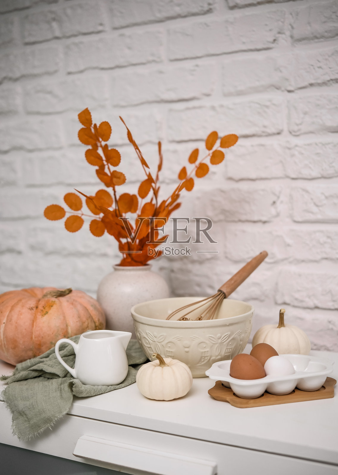 迷人的秋季厨房布置,展示五彩缤纷的南瓜和秋季炊具照片摄影图片