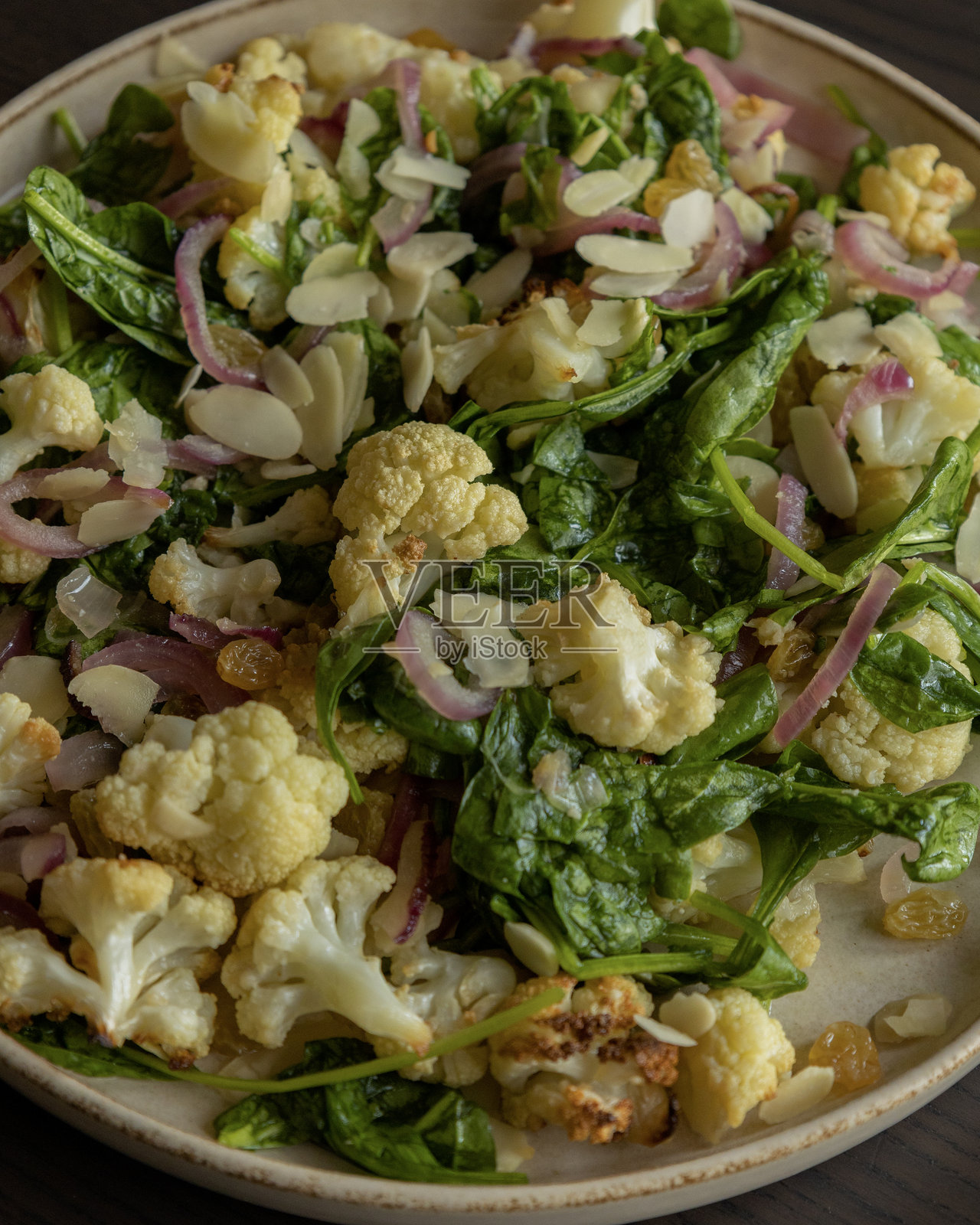 冬季沙拉 - 温暖的花椰菜配菠菜和杏仁 - 特写照片摄影图片