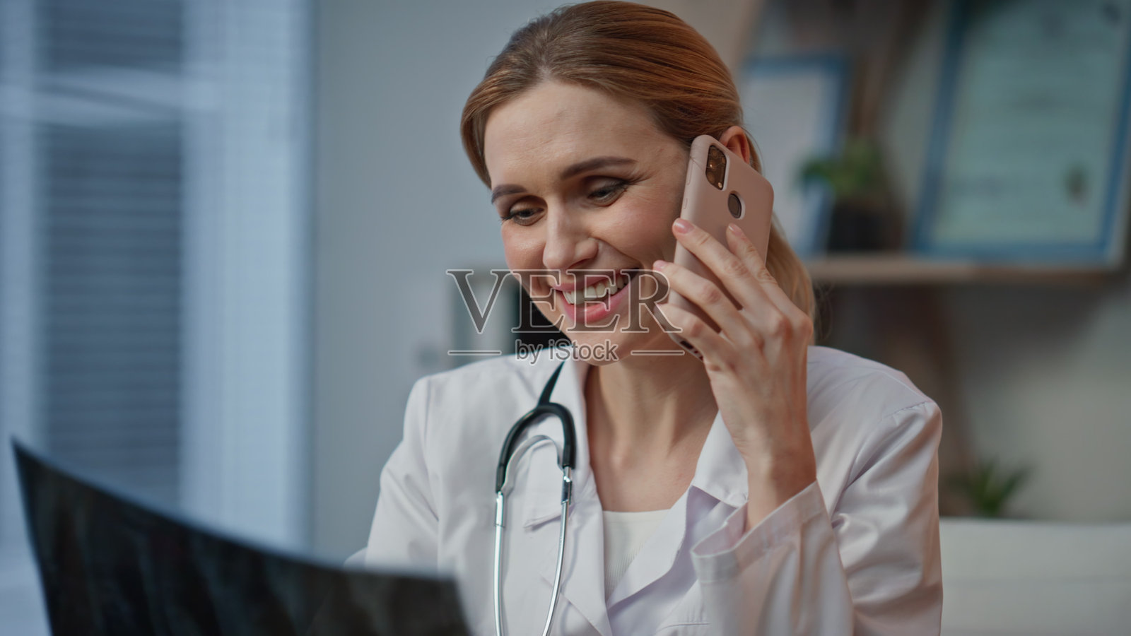 专业医生在电话中仔细审查医疗扫描,快乐的治疗师在诊所内。照片摄影图片