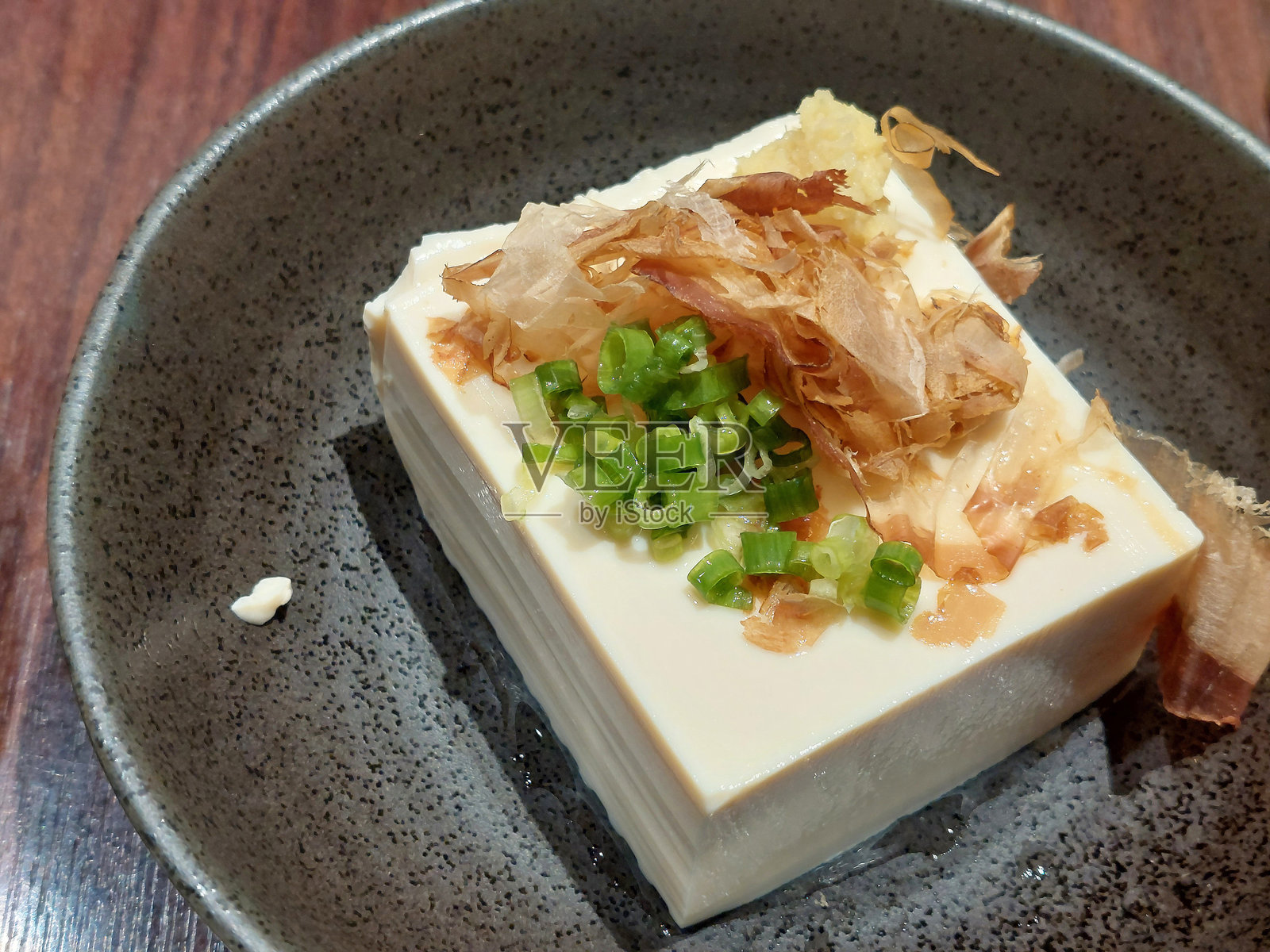 冷豆腐上撒有干 bonito 鱼片和葱花照片摄影图片