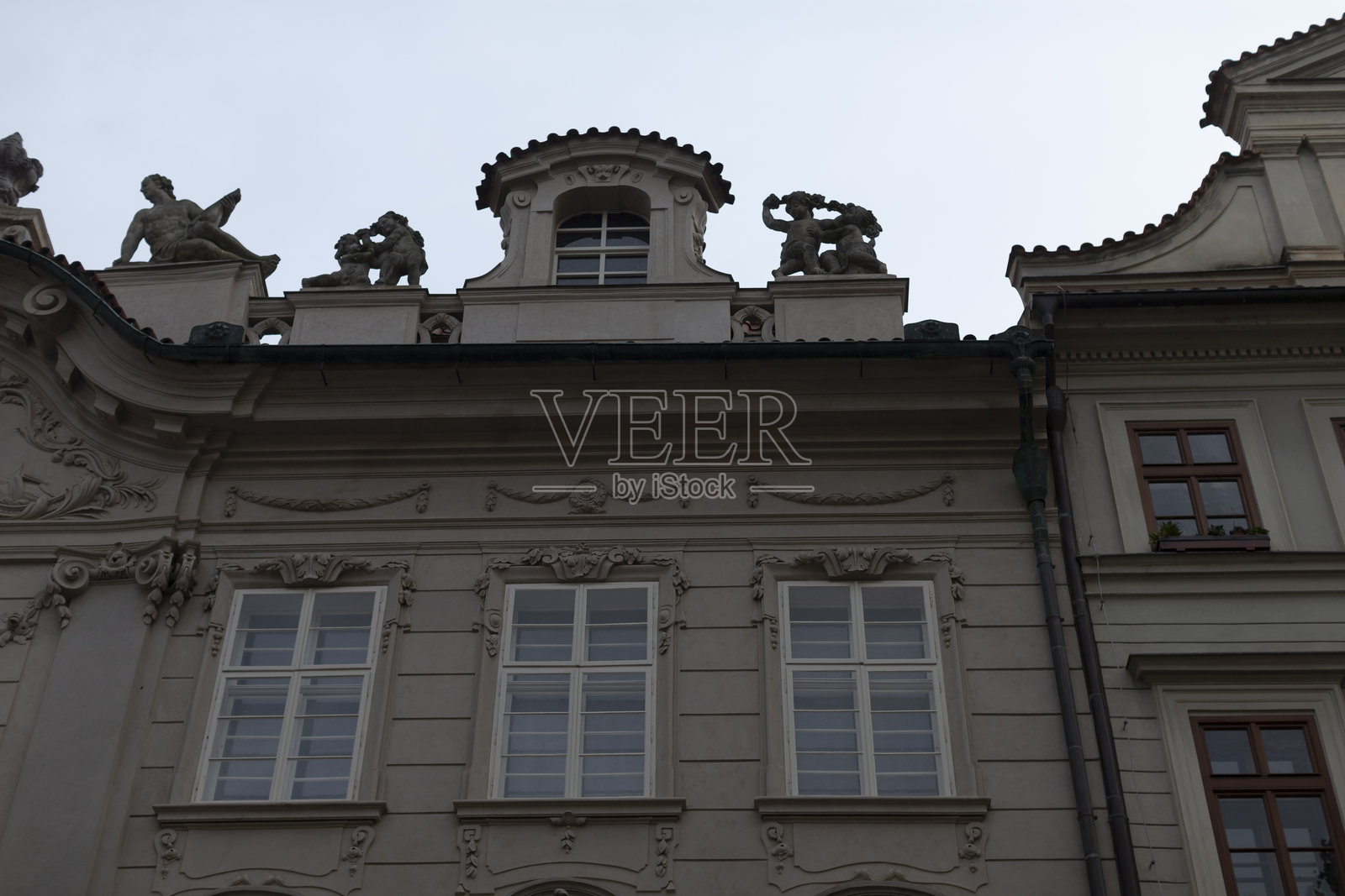 一座宏伟的建筑,屋顶上有众多窗户和令人印象深刻的雕像。照片摄影图片