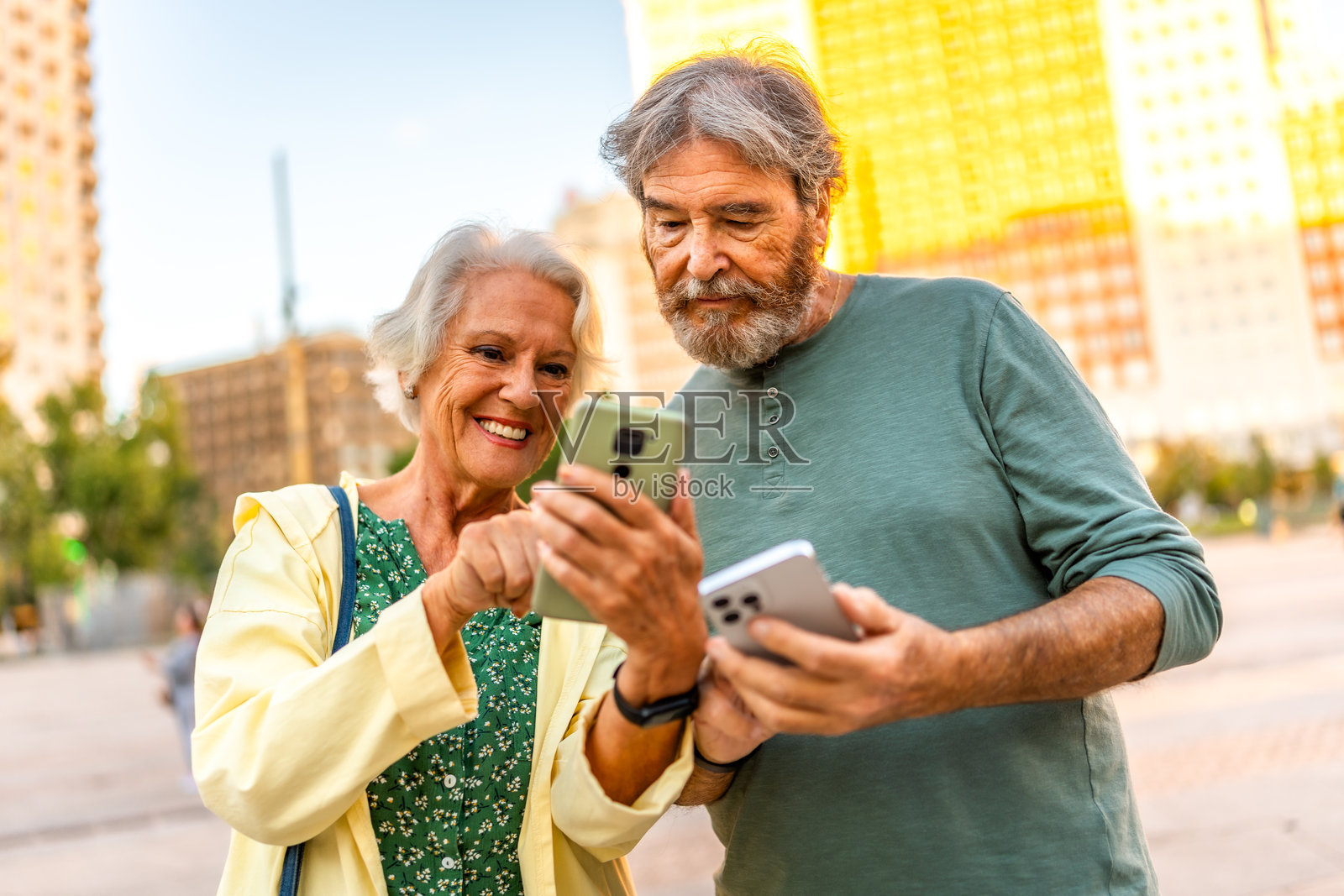 女性在户外向高级合伙人展示手机屏幕照片摄影图片