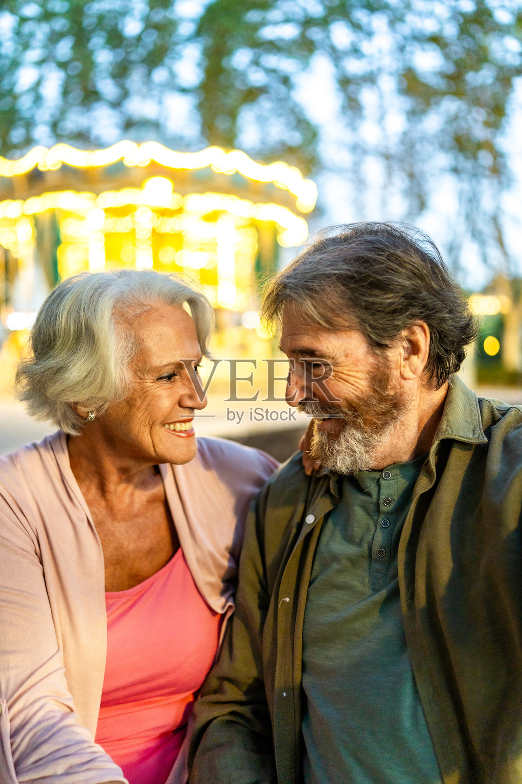 一对老年夫妇在城市集会上互相凝视。照片摄影图片