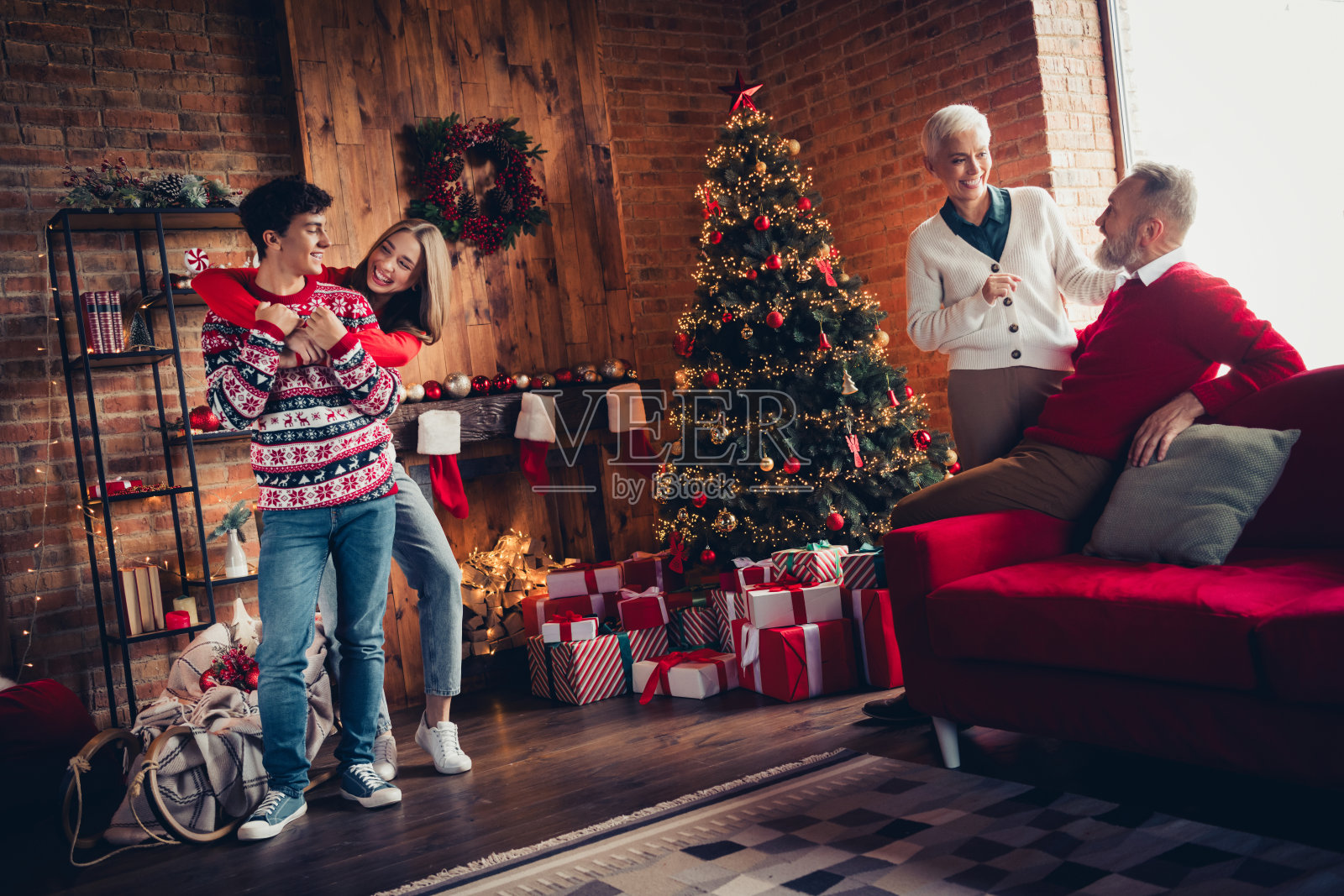 四个家庭成员在家中拥抱,享受圣诞和新年的快乐。照片摄影图片