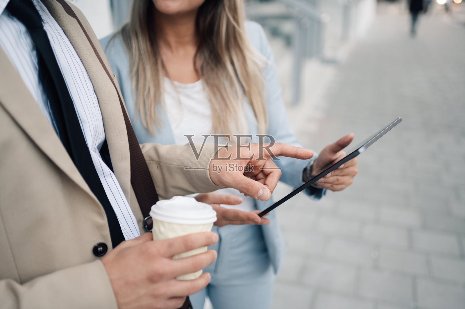 商务人士在户外使用平板电脑进行非正式会议照片摄影图片