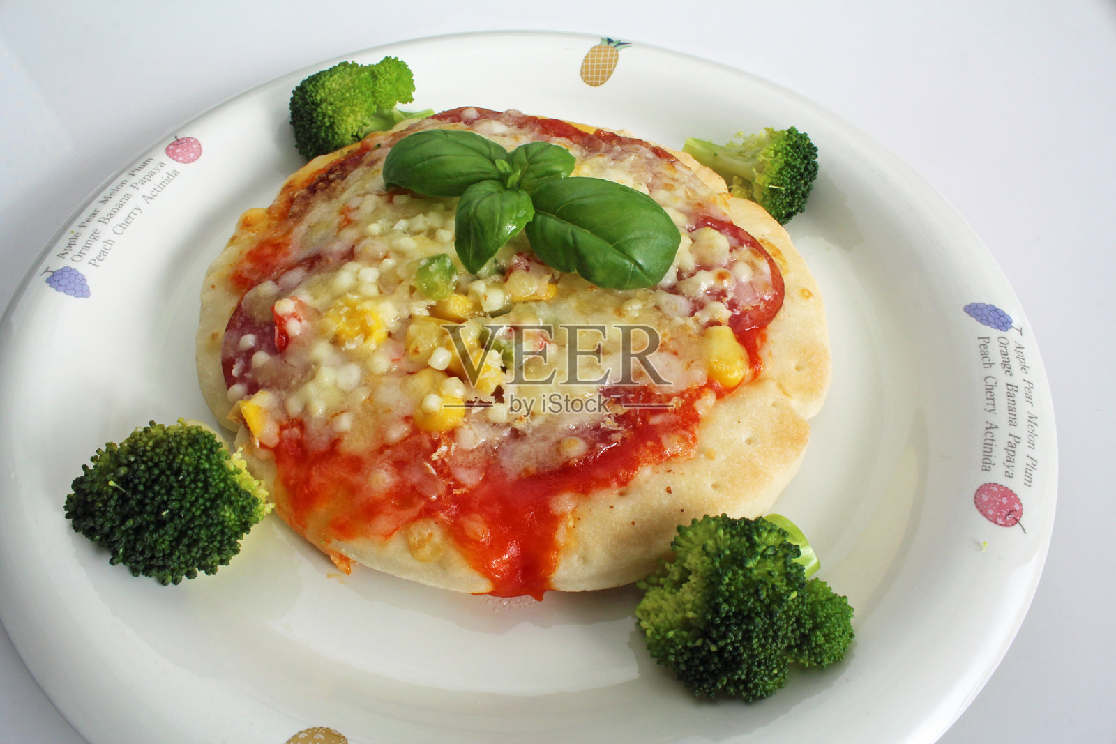 小披萨配玉米,旁边有西兰花照片摄影图片