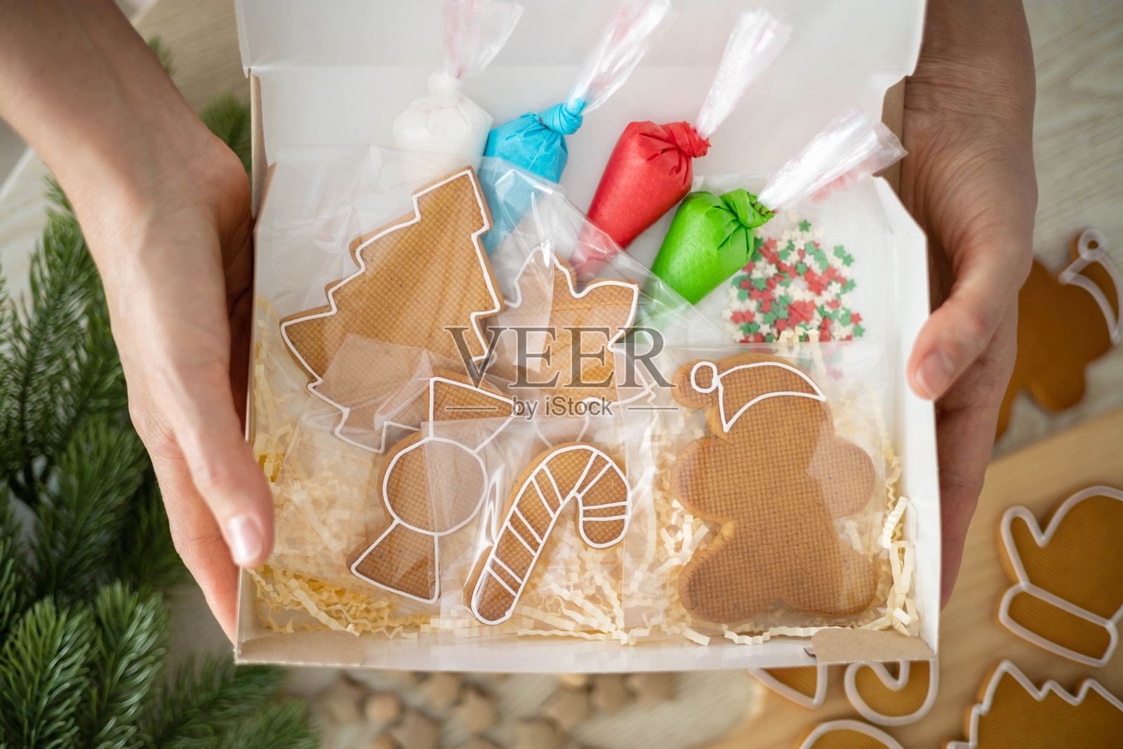 女人手持装有自制圣诞姜饼的盒子,特写视角。照片摄影图片