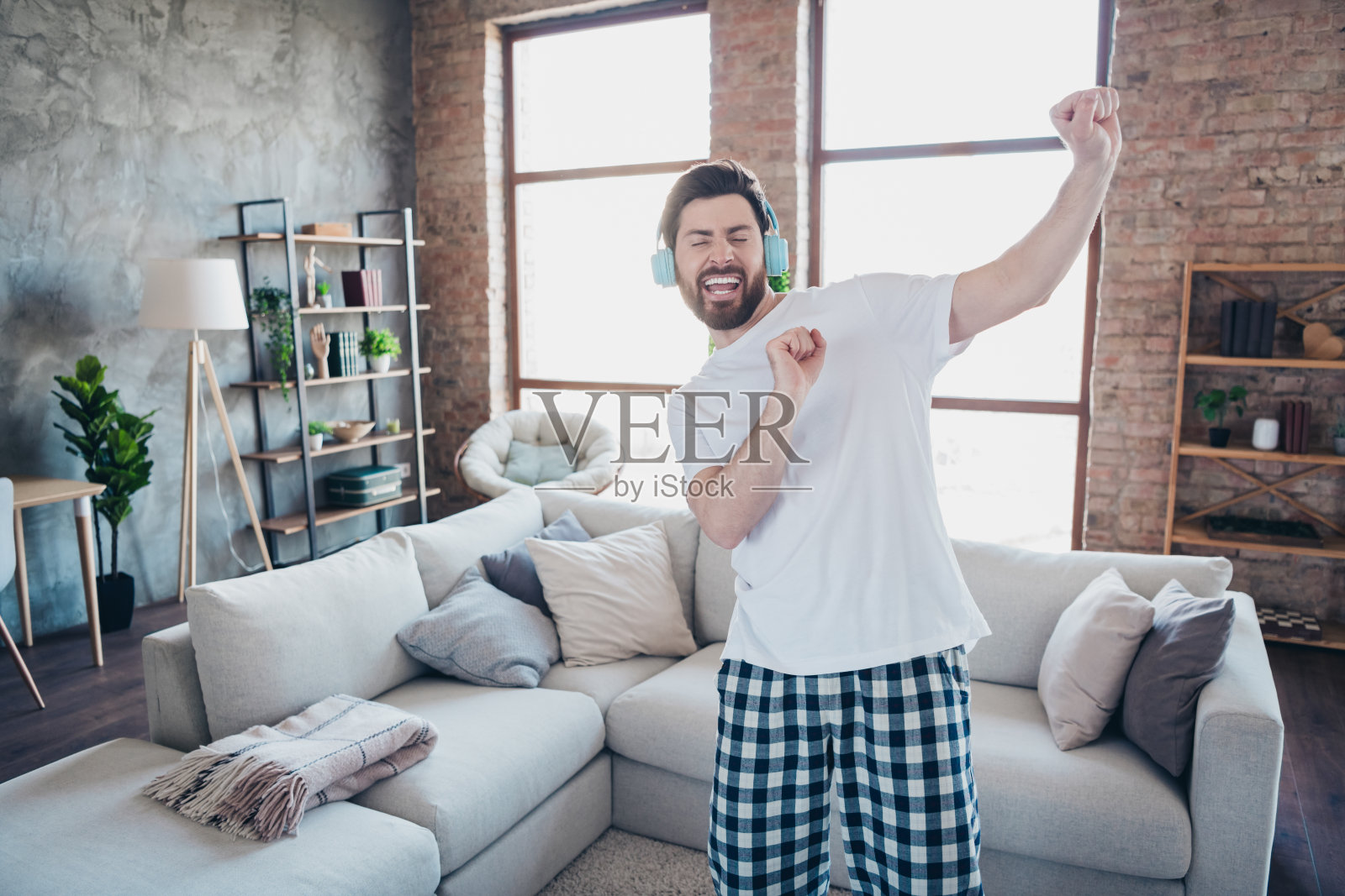 穿着睡衣的迷人快乐乐观男子在室内客厅独自享受周末舞蹈的乐趣照片摄影图片