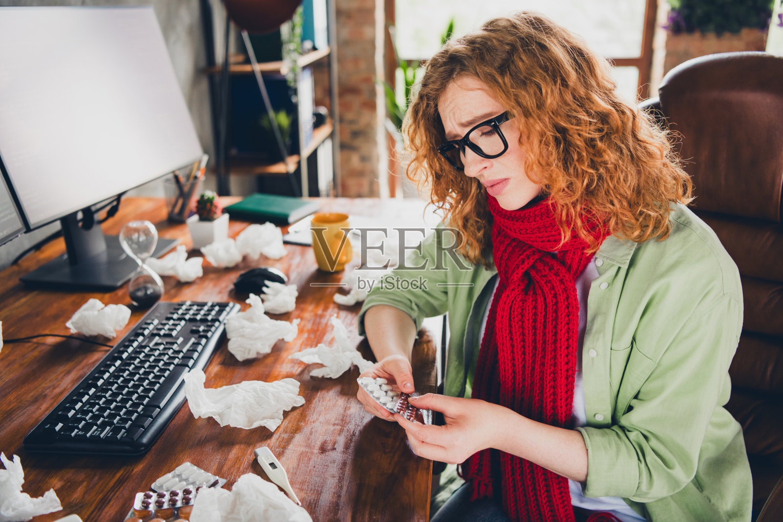 一位不开心的女助理穿着衬衫和眼镜,在室内工作场所服用药物,感冒了。照片摄影图片