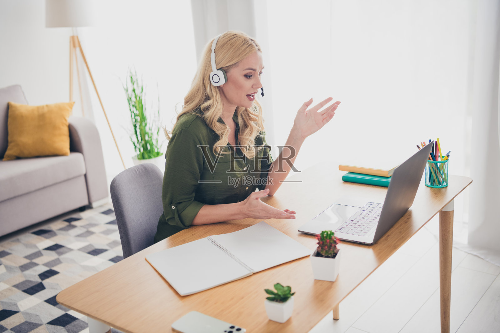 迷人可爱的女性顾问坐在家中公寓的工作桌前工作照片摄影图片