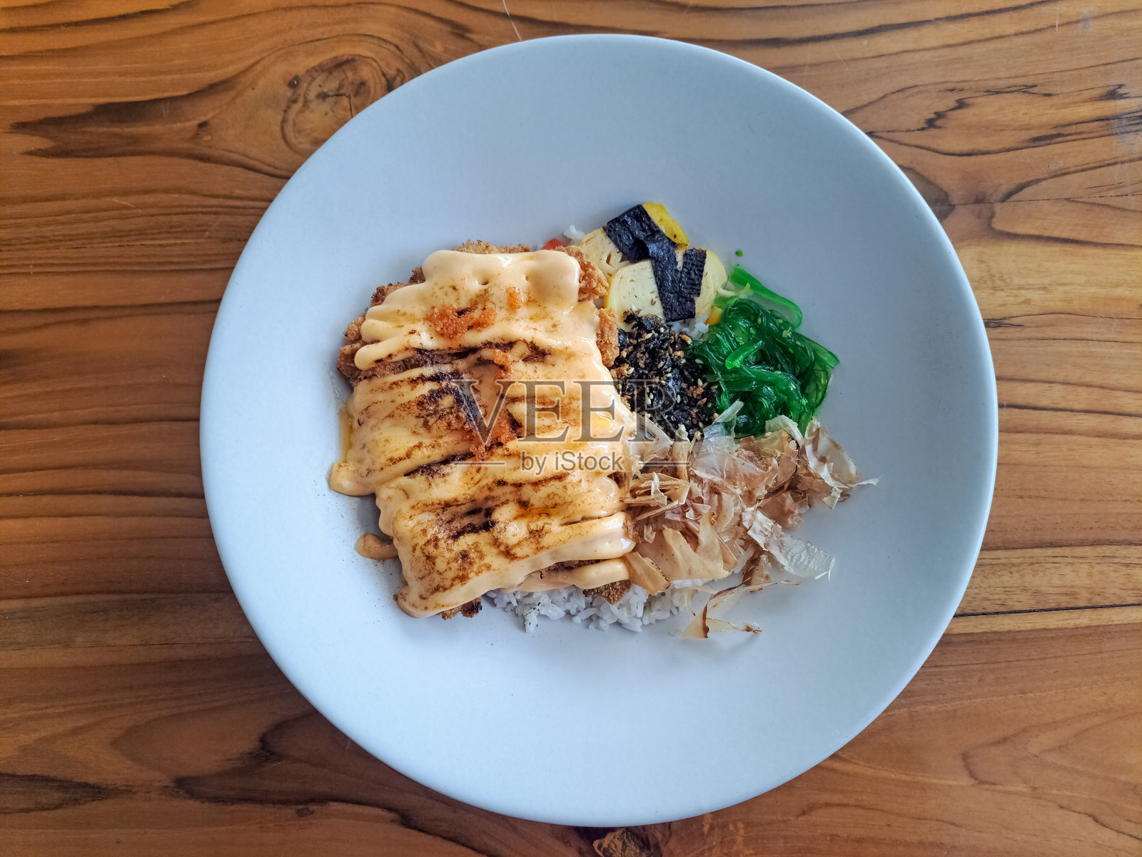 脆皮鸡明太子配黄油饭、鸡排、明太子酱、海苔、鸡蛋、鲣鱼 flakes、飞鱼卵、凉拌海带。食品菜单。俯视图。照片摄影图片