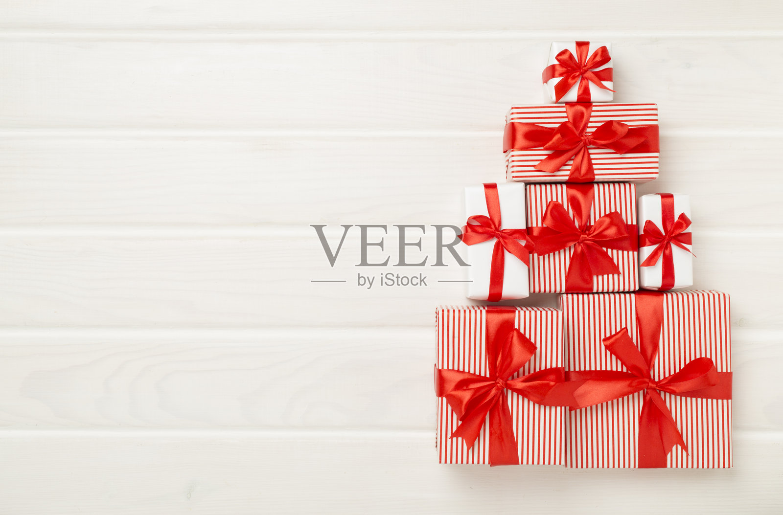 木质背景上的圣诞树形状礼品盒,俯视图照片摄影图片