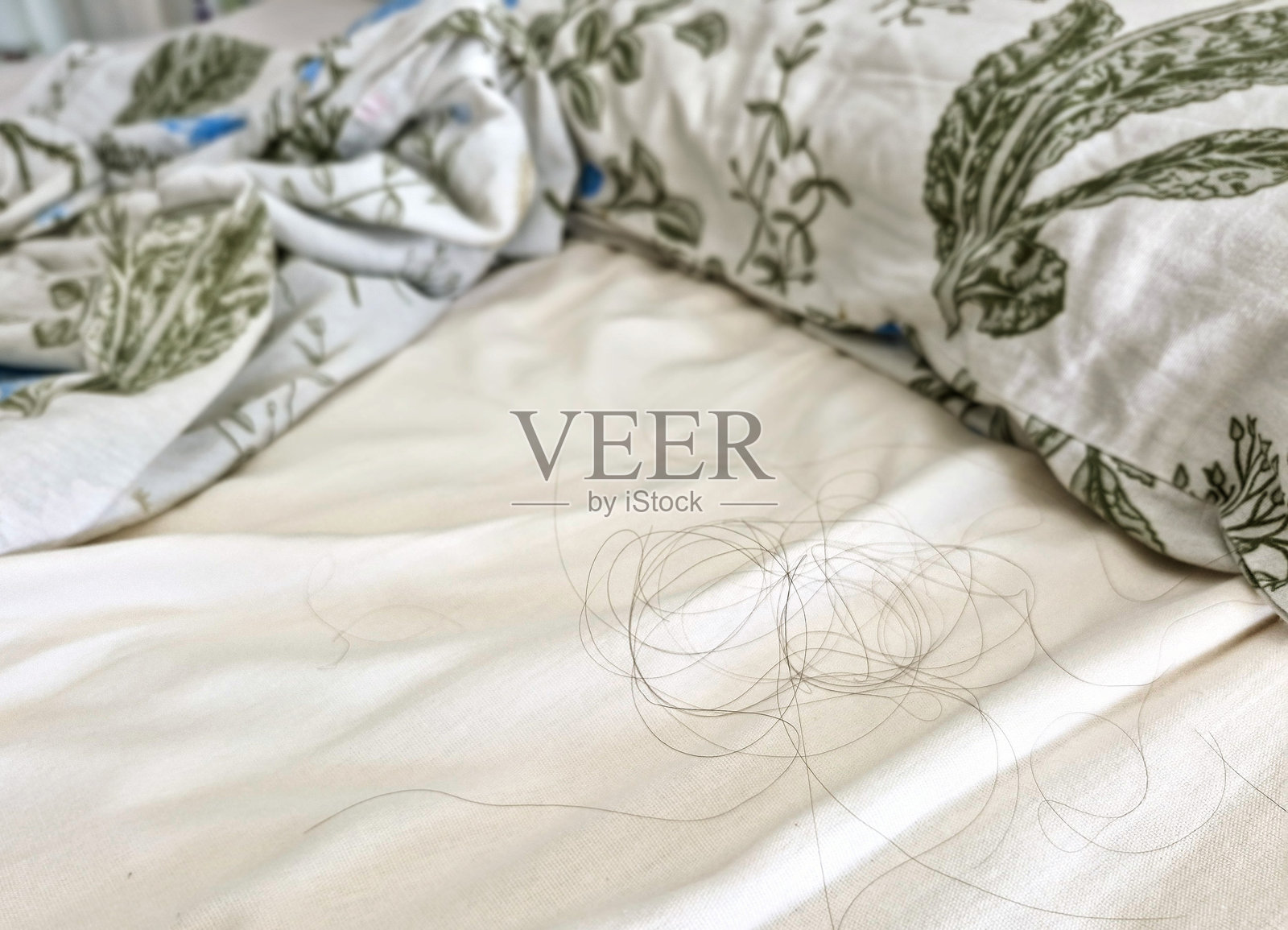 脱发 - 睡觉后床上躺着的几缕头发照片摄影图片