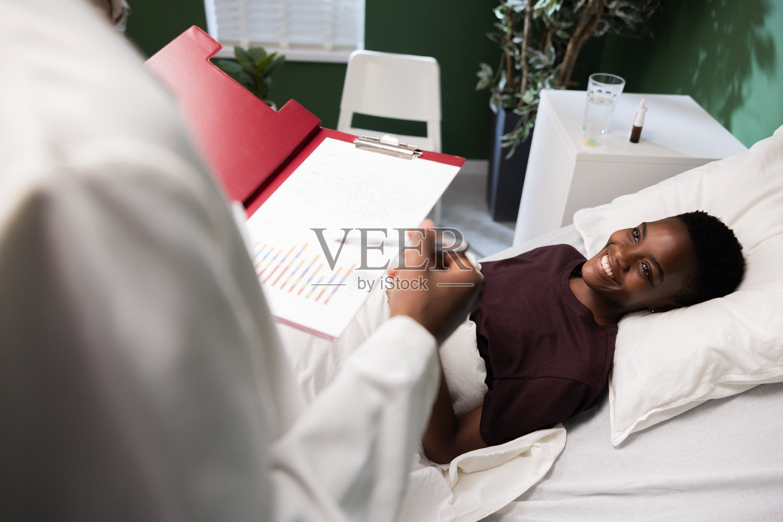 非洲医生与患者讨论健康问题,手中拿着一些文件。照片摄影图片