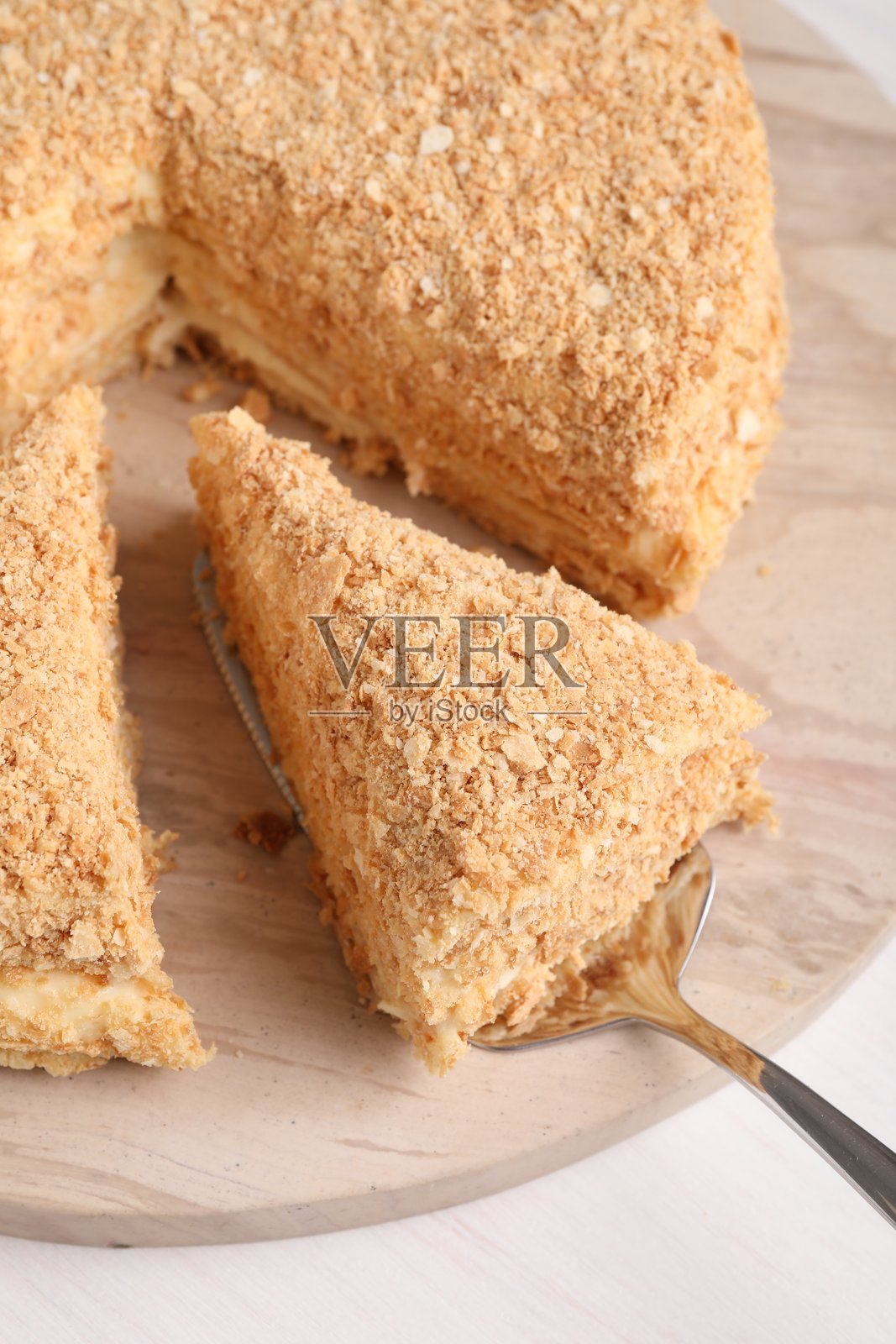 从桌子上拿起一块美味的拿破仑蛋糕,俯视图照片摄影图片