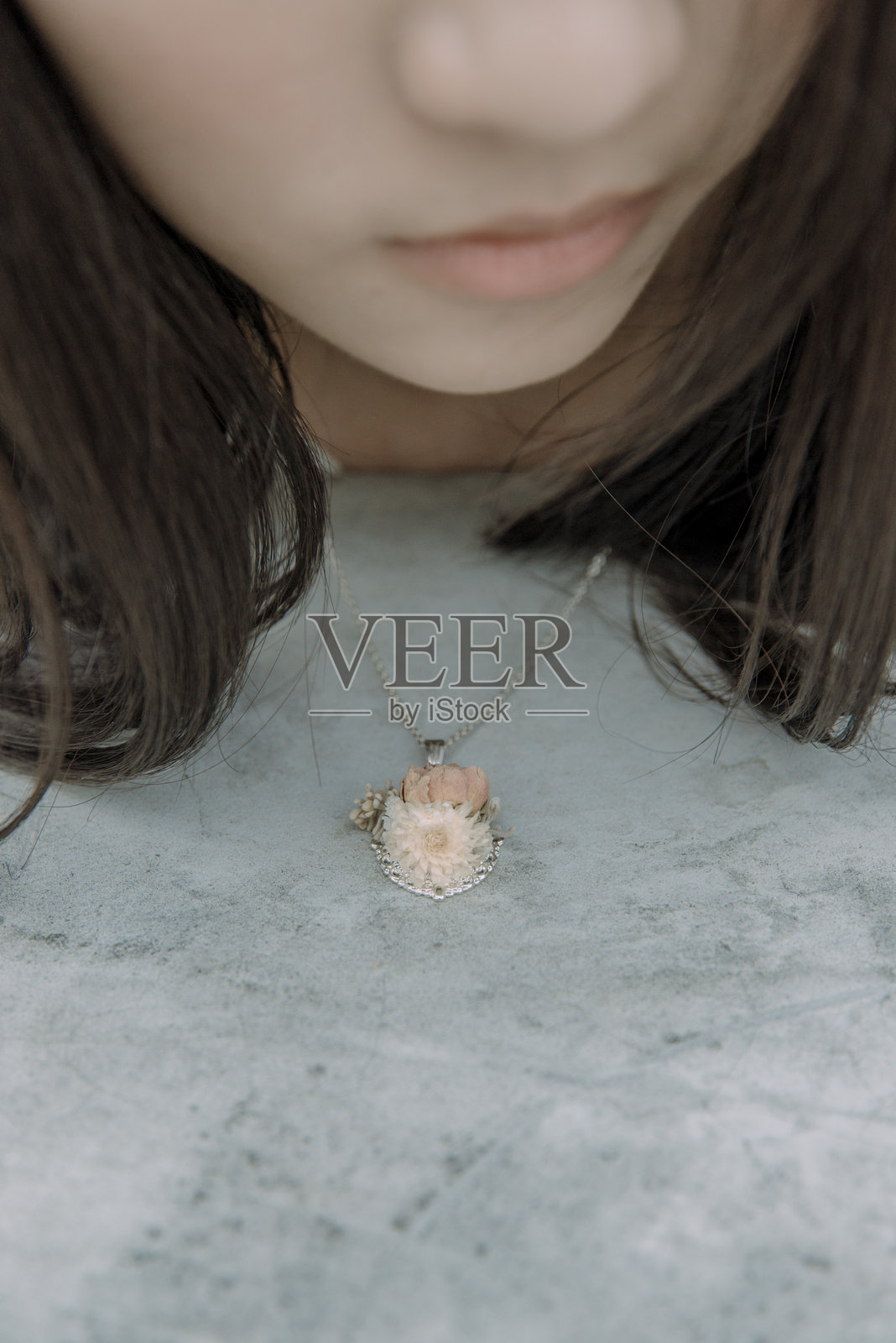 年轻女性佩戴链条坐在护墙上照片摄影图片