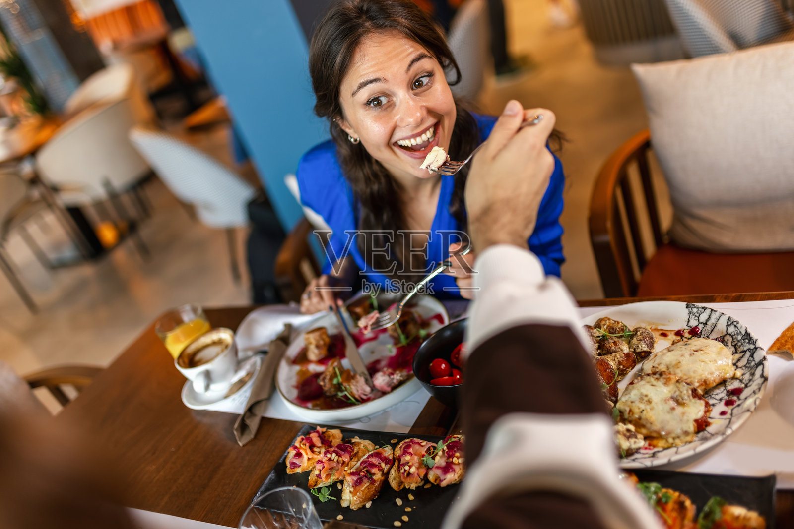 情侣在餐厅里互相喂食,享用美味的食物。照片摄影图片
