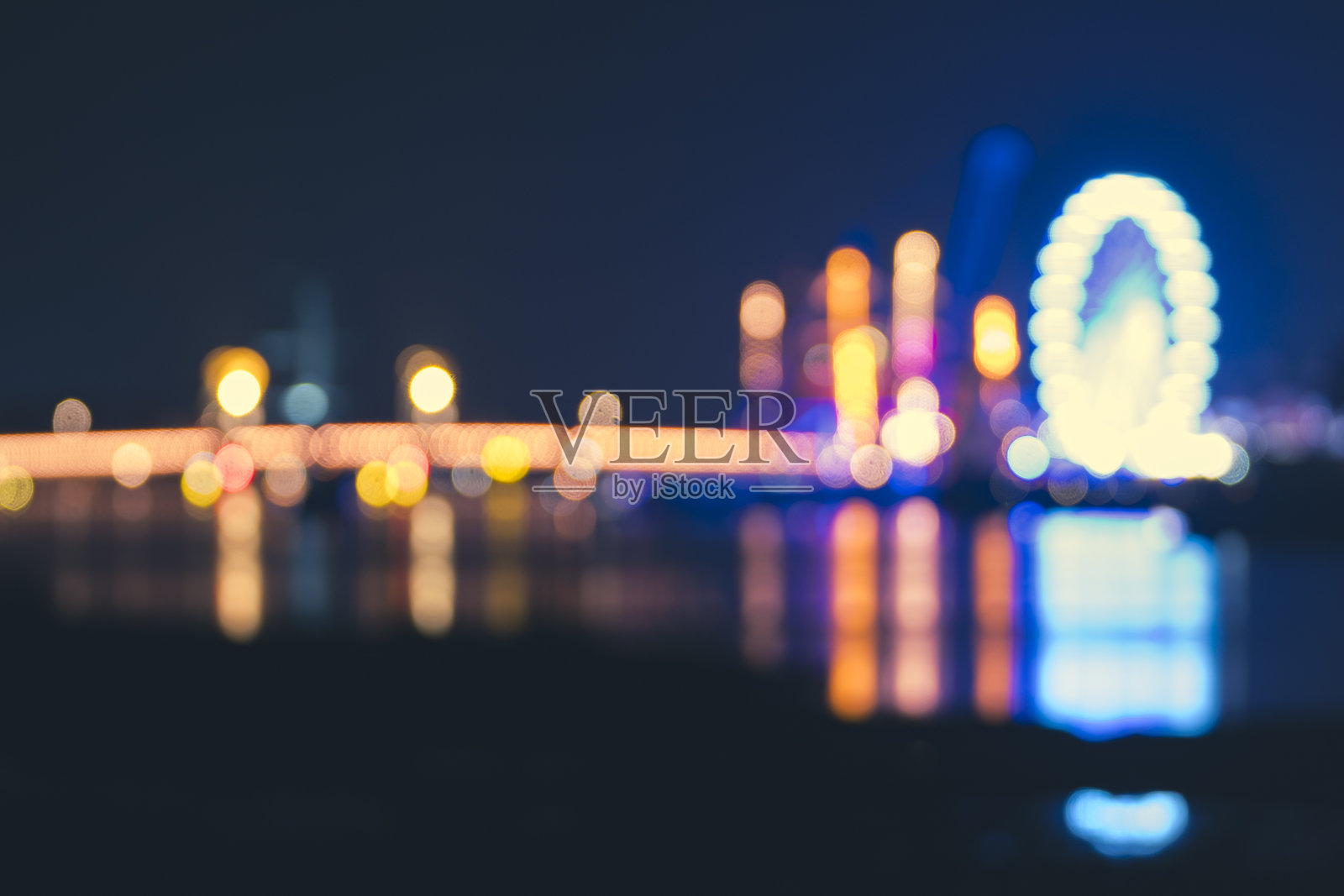 夜晚城市景观,模糊背景中的活动五彩灯光及河面倒影照片摄影图片