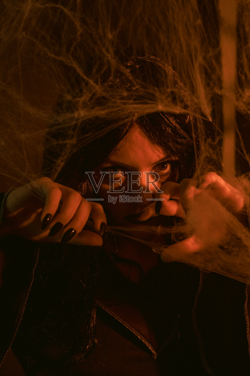 万圣节的女巫肖像,背后是蛛网照片摄影图片