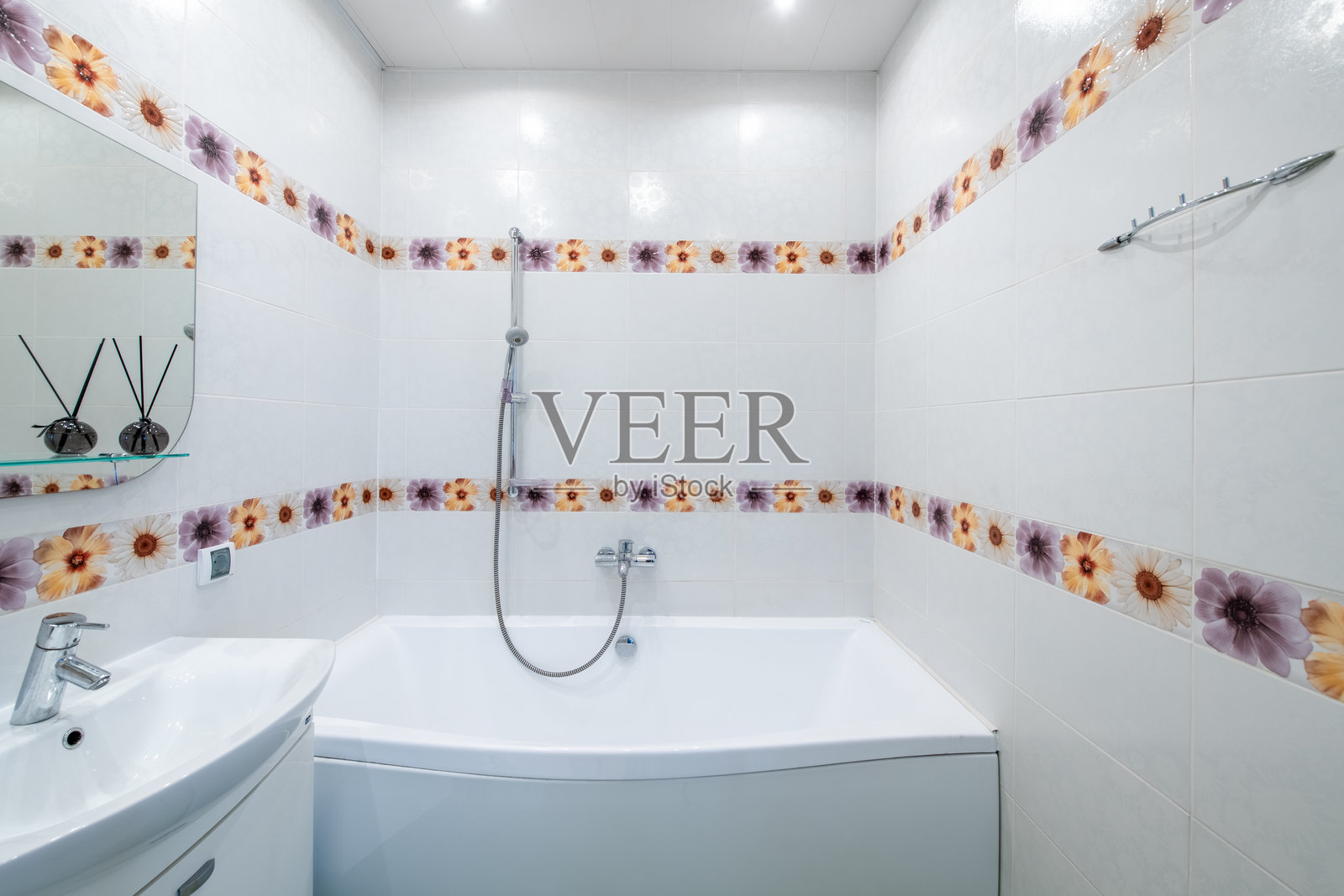 明亮优雅的现代奢华家居浴室室内设计,配有白色洗手盆、镜子和水龙头,LED灯,淋浴区,瓷砖地板和墙壁。照片摄影图片