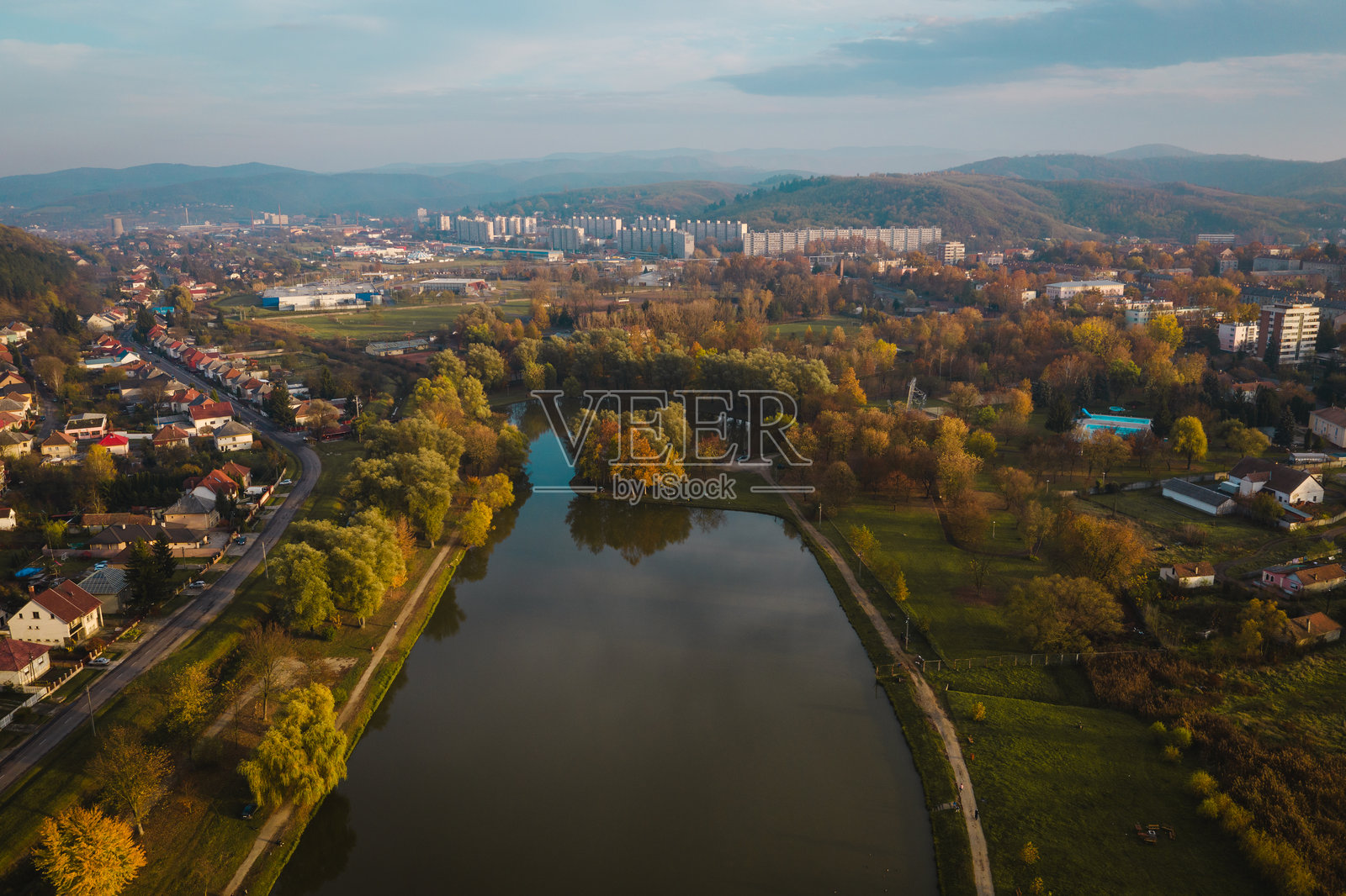 秋季树叶环绕的湖泊和城市景观的鸟瞰图照片摄影图片