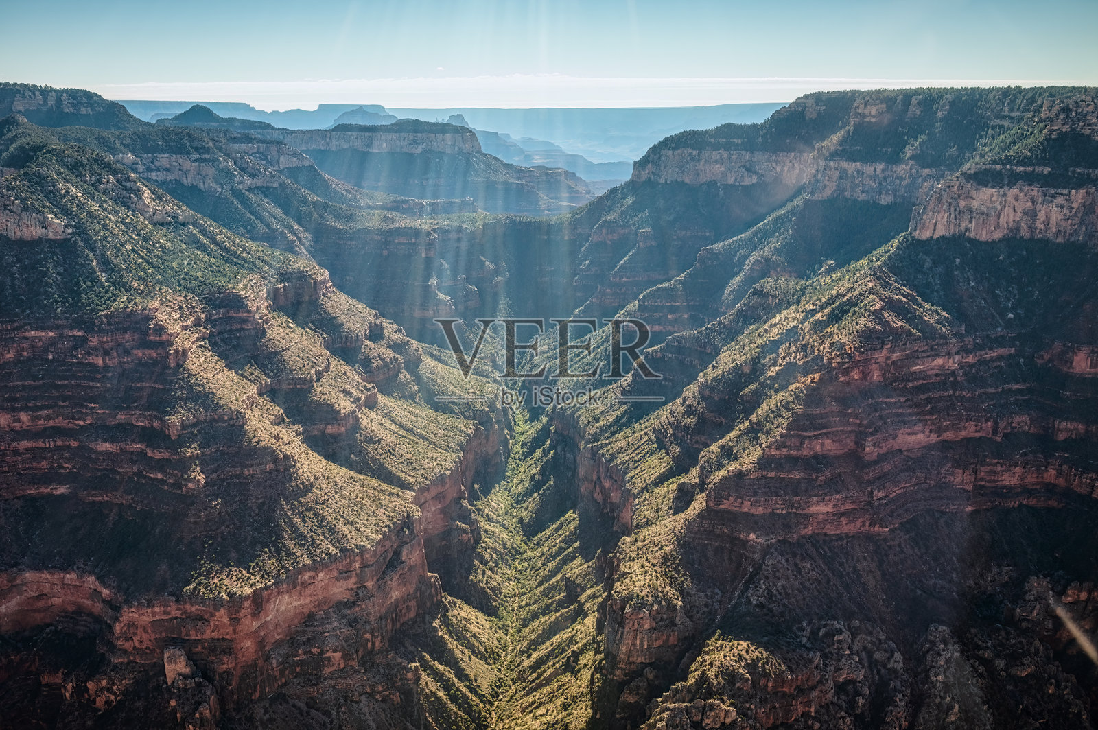 直升机俯瞰阳光照耀下的亚利桑那州大峡谷翠绿山谷照片摄影图片