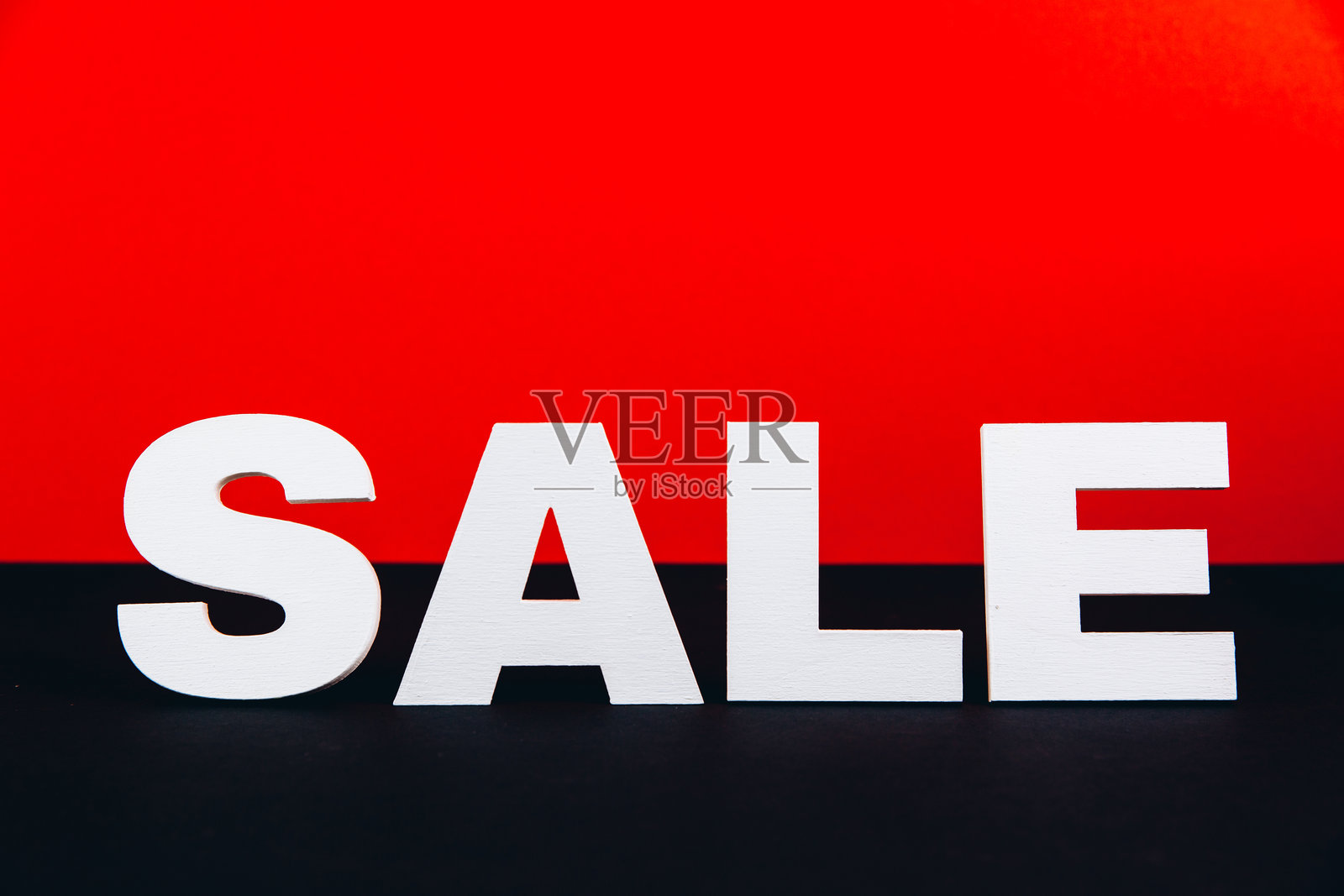 红黑背景上的白色木质“特卖”字样。购物和黑色星期五概念照片摄影图片