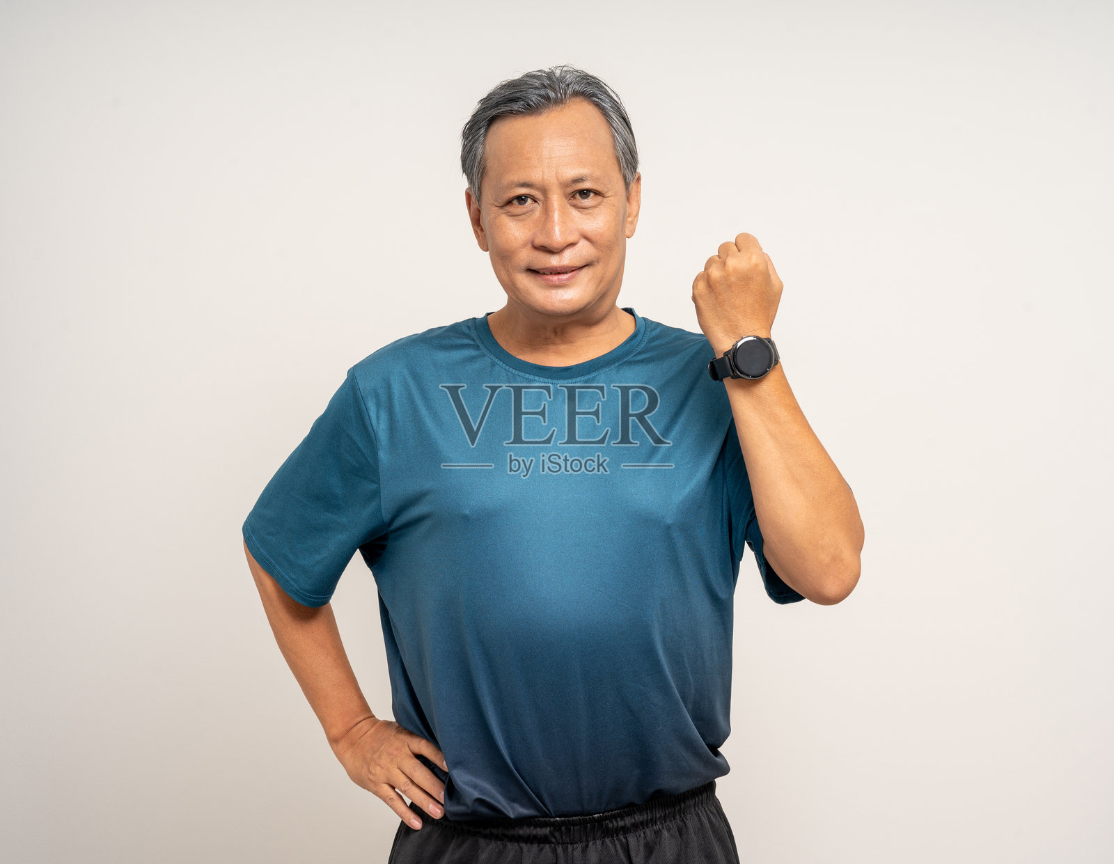 穿着运动服的老年男性在孤立背景下使用智能手表显示心率监测。健康和运动模式的科技。锻炼并记录数据以提升潜力。照片摄影图片