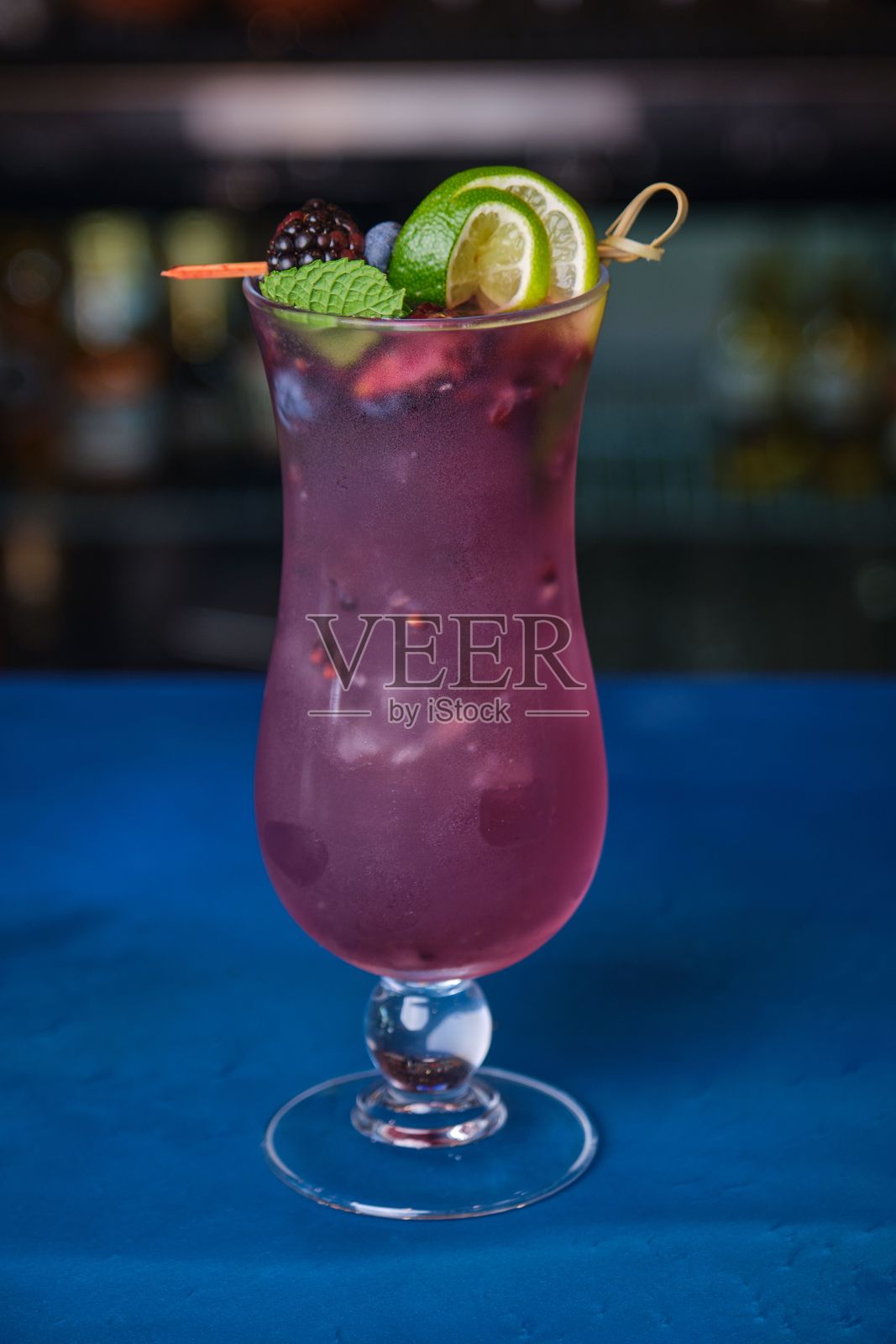 清新的紫色黑莓鸡尾酒,杯中装饰着新鲜的黑莓和薄荷叶照片摄影图片