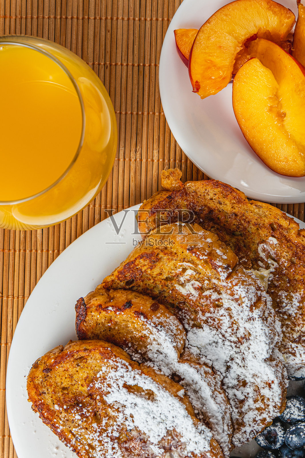 早餐盘子上的法式吐司,配有蓝莓、橙汁和油桃照片摄影图片