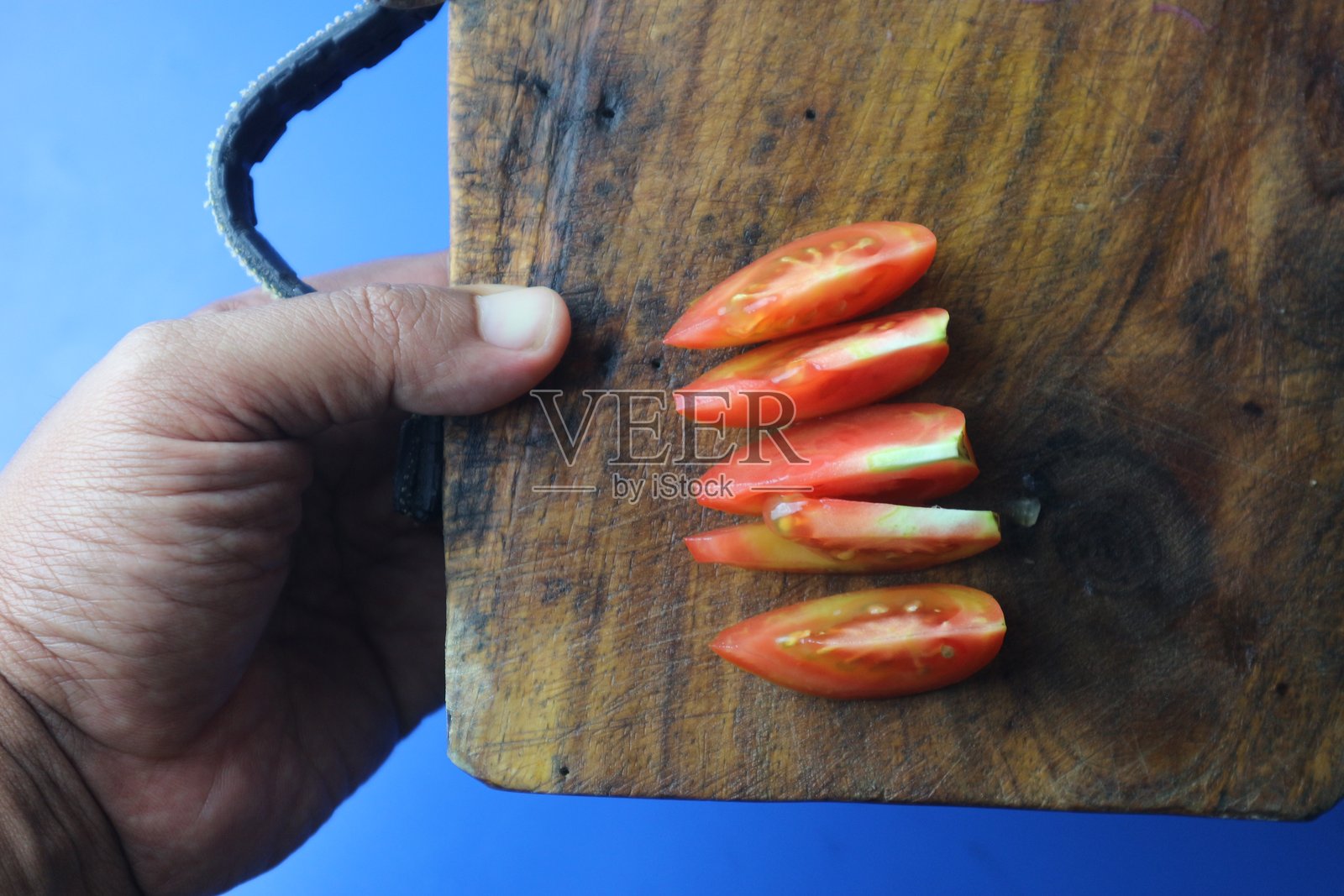切好的番茄放在切菜板上,旁边有一把刀。照片摄影图片