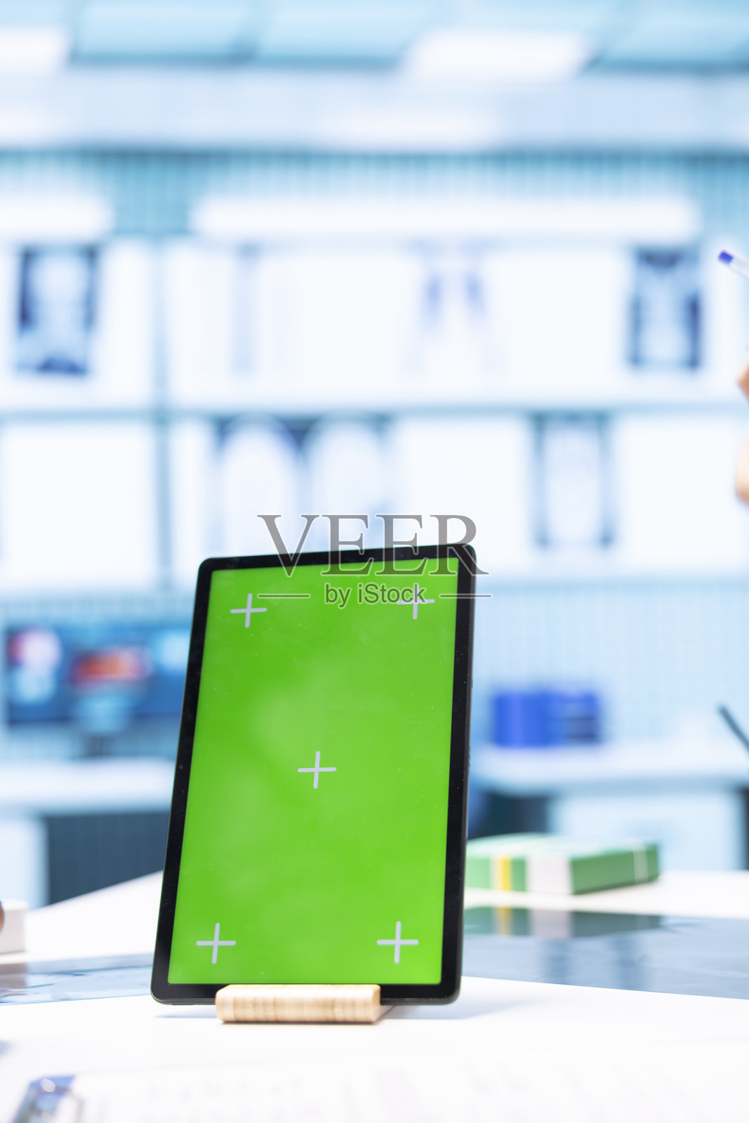 医生在医疗设施中与男性患者咨询,旁边有绿色背景屏幕。照片摄影图片