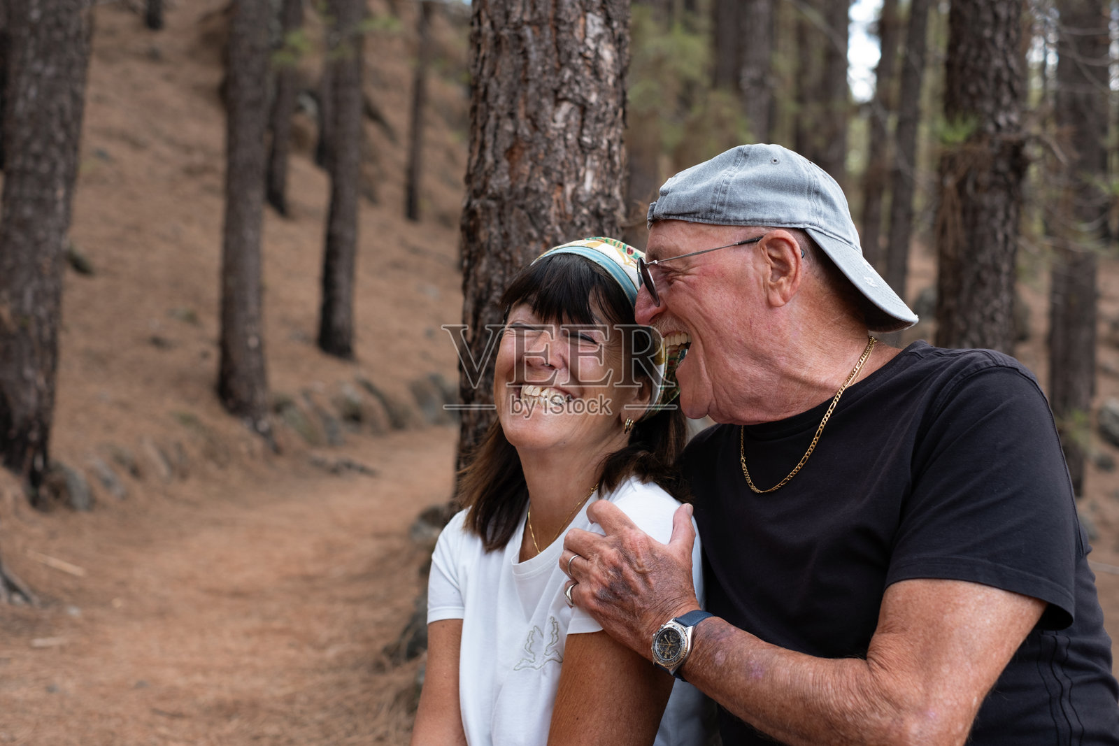 快乐的老年夫妇在山中徒步旅行,表达着幸福和健康。愉快的老年男女无忧无虑地欢笑。照片摄影图片
