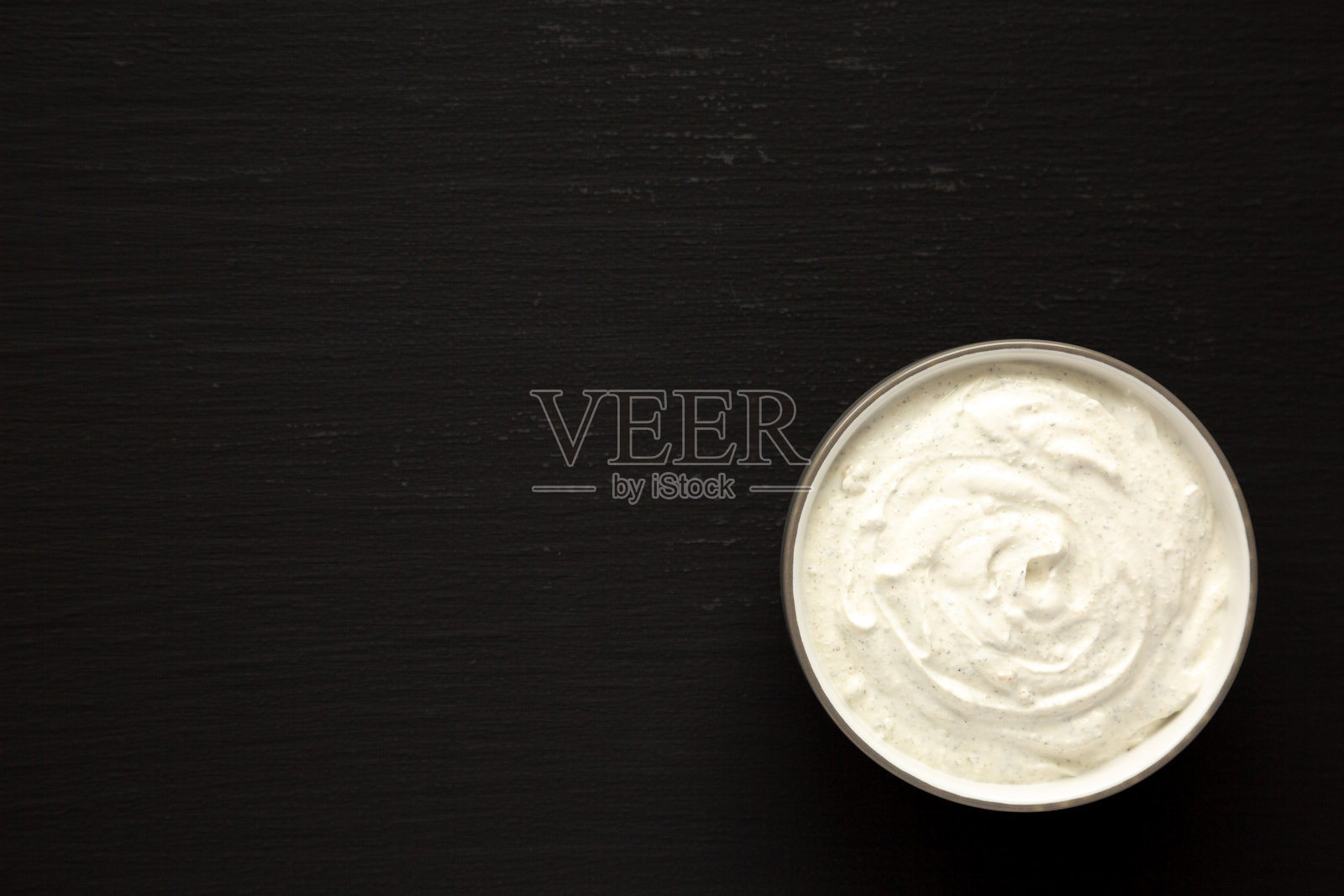 黑色背景上的碗中自制牧场沙拉酱,俯视图。平铺,顶部视角,留白空间。照片摄影图片