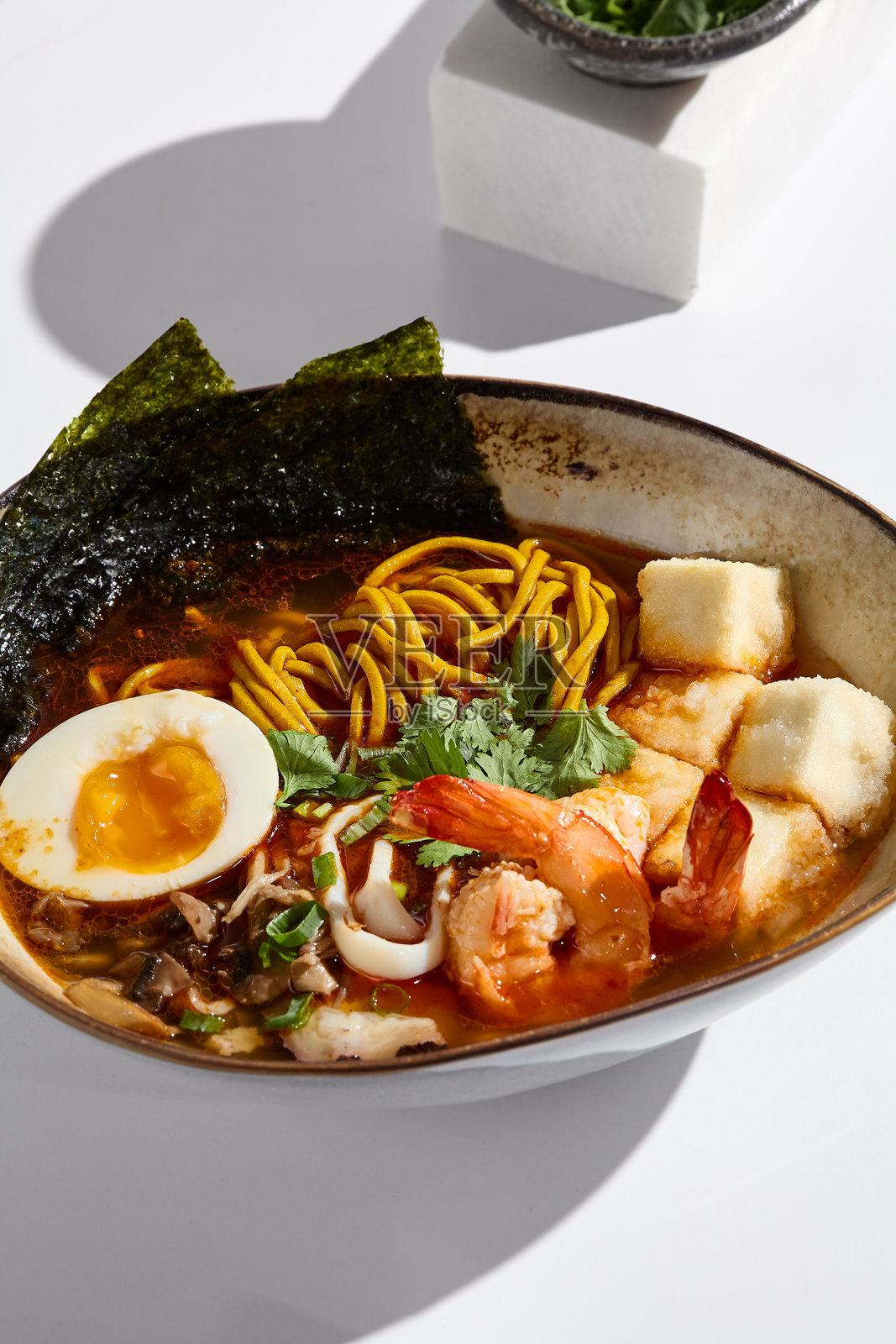 明亮工作室灯光下的生动豆腐虾拉面碗照片摄影图片