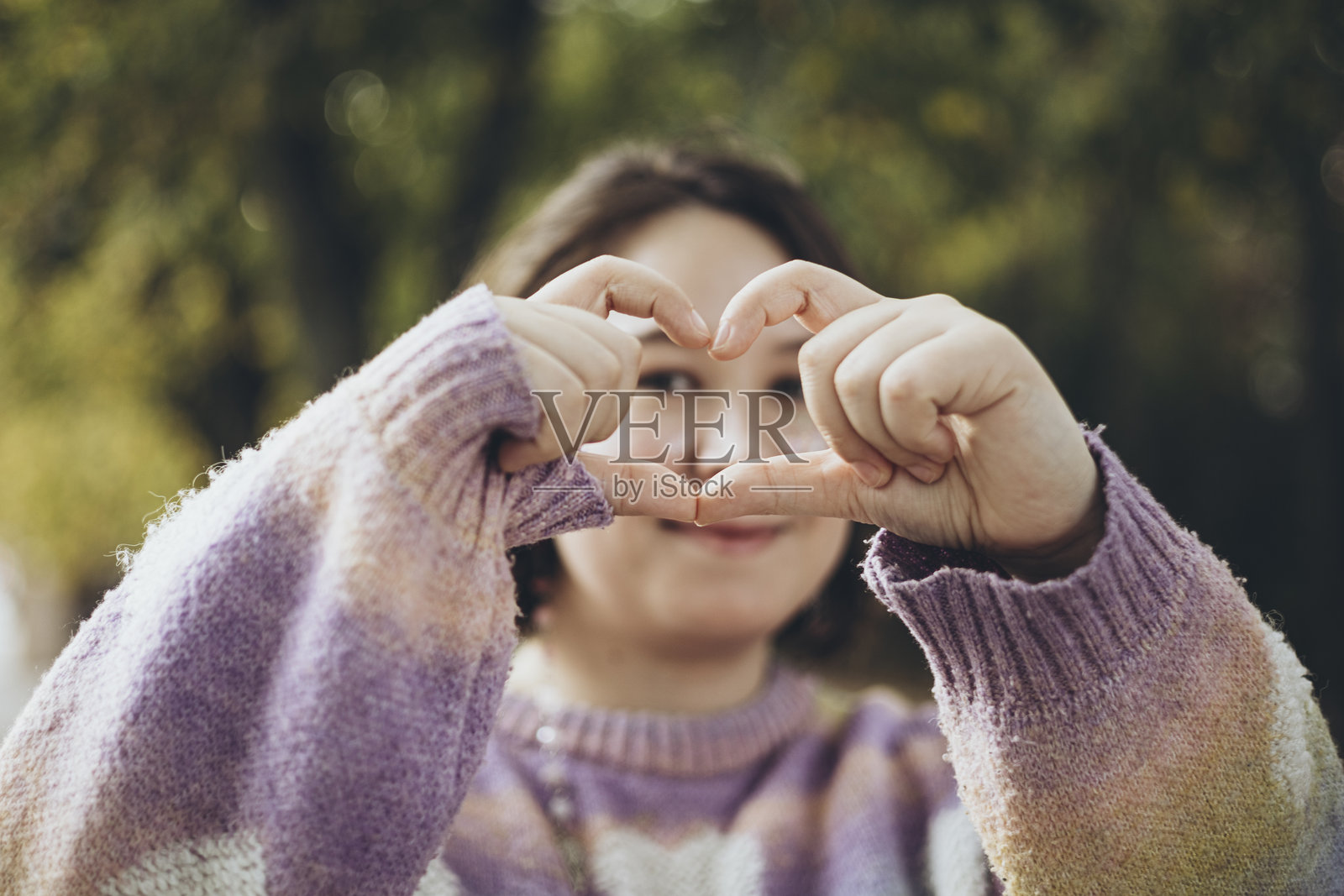 女人用手指做出一个心形,表达自爱、关怀和健康的概念。照片摄影图片