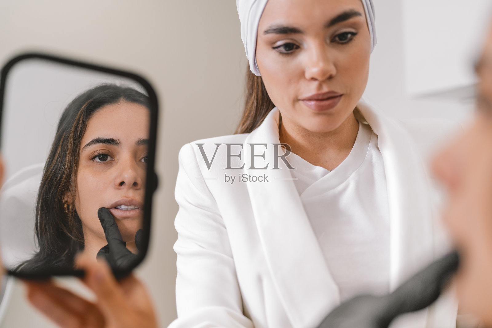 医生使用镜子解释面部美容手术治疗照片摄影图片