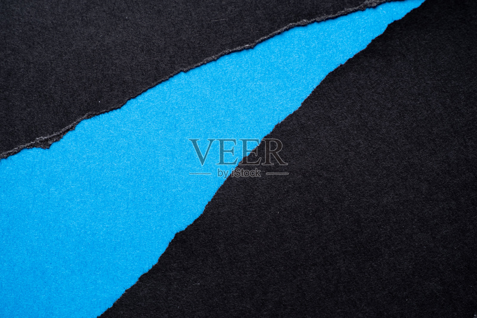 撕裂的黑纸上有蓝色背景照片摄影图片