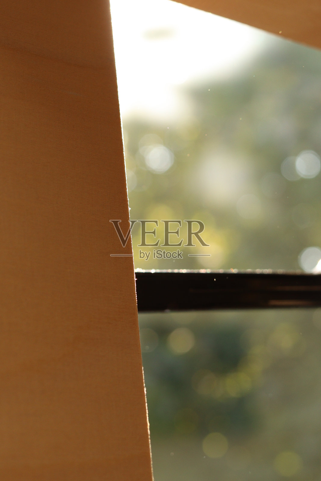 窗外视野,模糊的绿色散景光线,自然花园。模糊的窗户背景用于产品展示的底纹。照片摄影图片