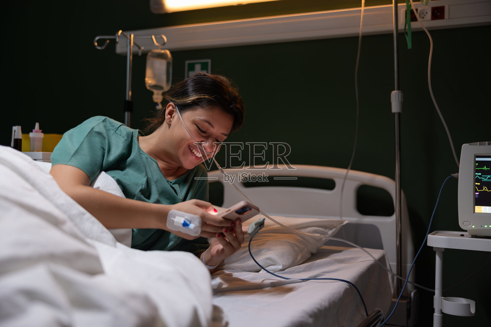 年轻女孩用手机给住院的家人发短信,因为她发生了严重的事故。照片摄影图片
