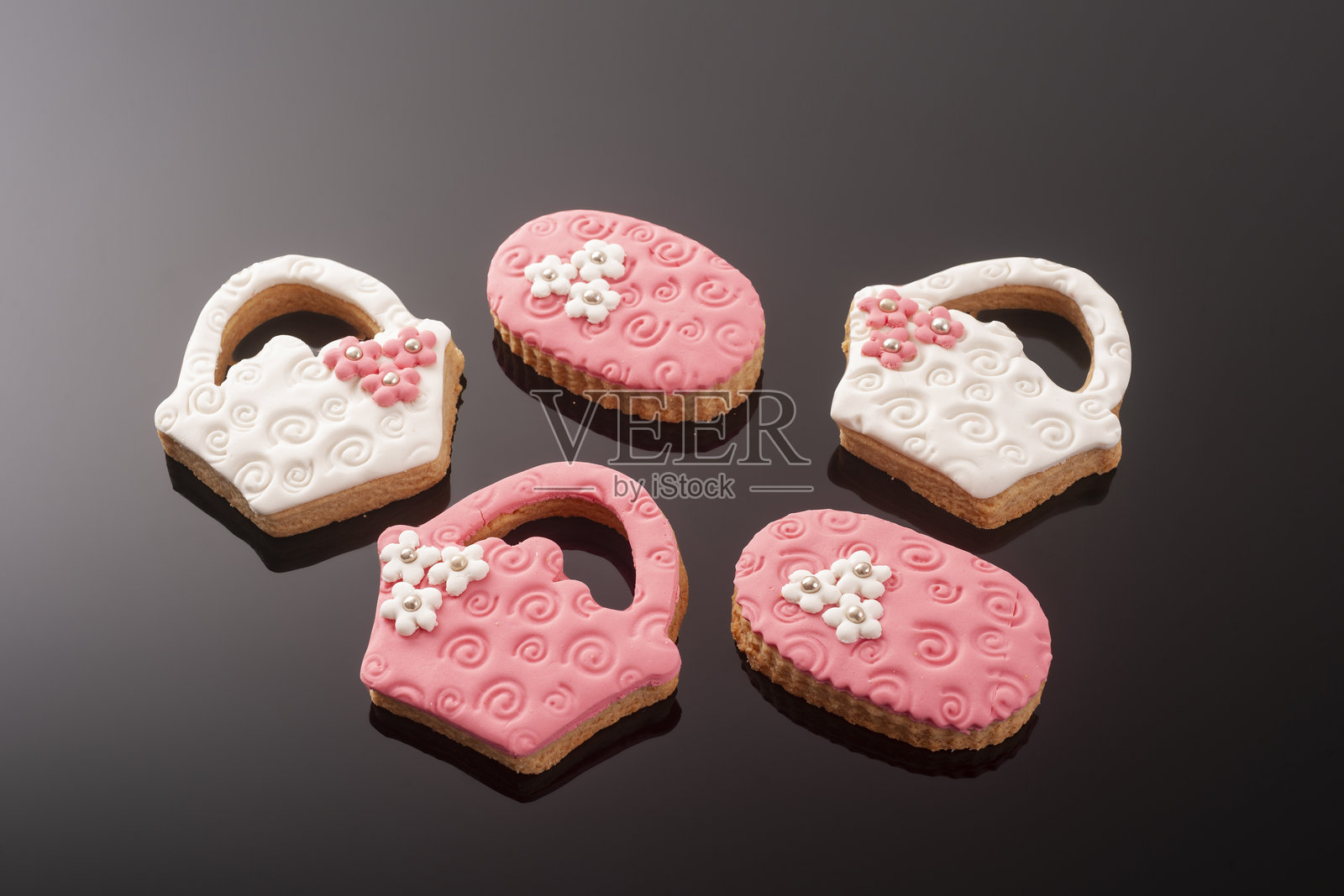 黑色背景上的婴儿饼干,装饰有糖霜。婴儿女孩。照片摄影图片