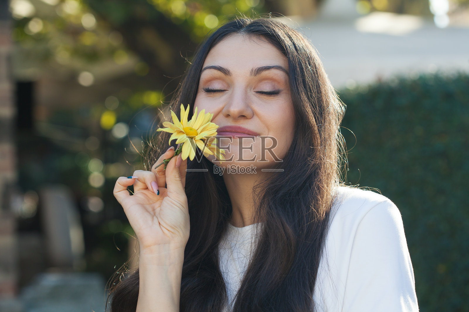美丽的年轻女性在闻花香照片摄影图片